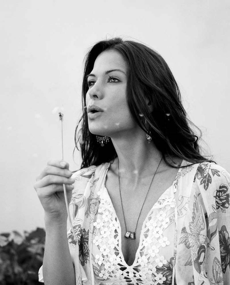 美女 桌布 壁紙 — 一位身穿花卉連衣裙的女性在柔和的黑白肖像中輕輕吹散蒲公英種子。