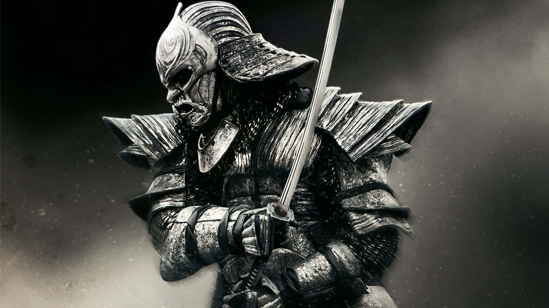 Black And White Samurai 桌布 壁紙 — 一位身穿華麗暗色鎧甲的武士戰士，在煙霧彌漫的灰色背景下，以戲劇性的燈光緊握武士刀。