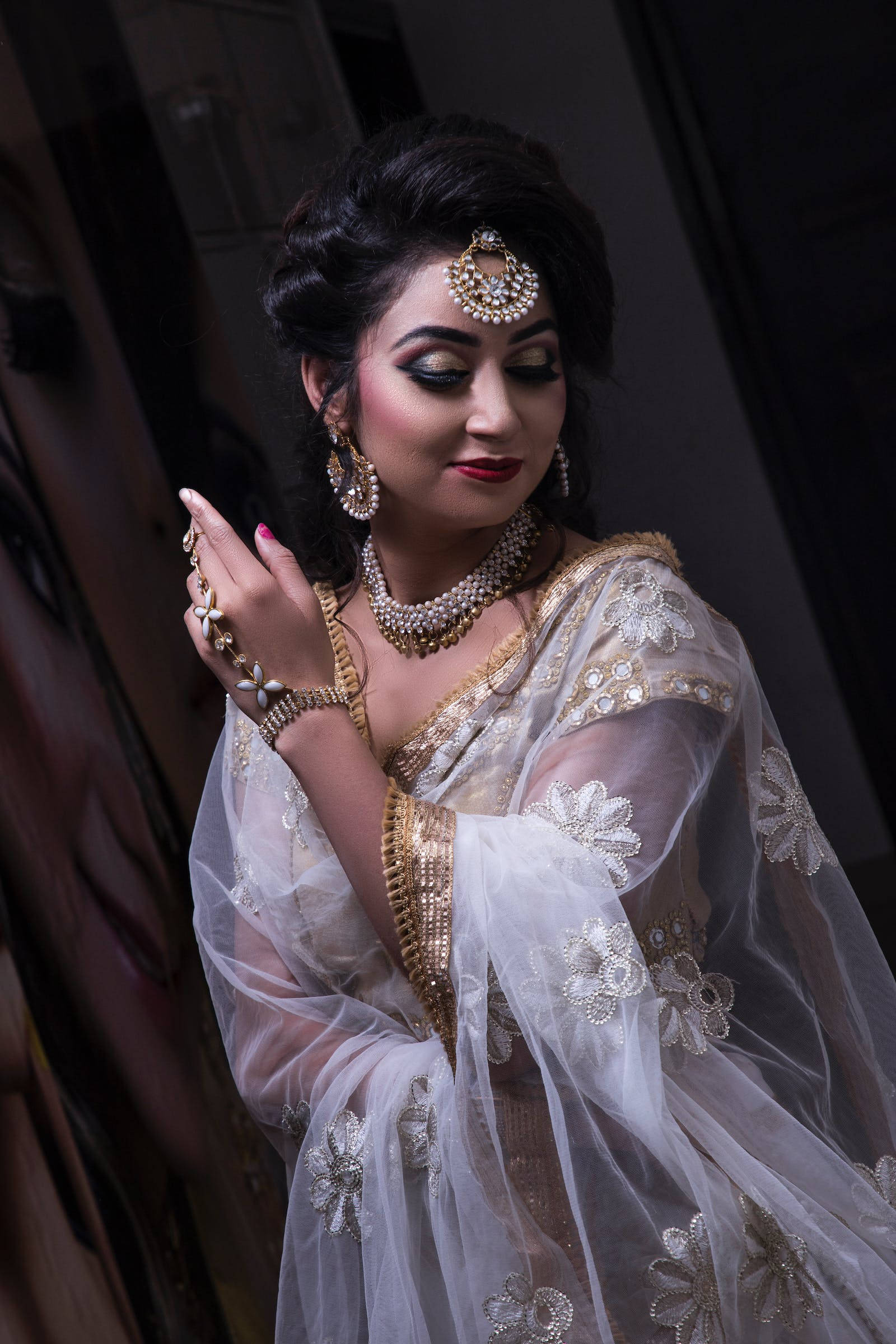 Indian 桌布 壁紙 — 一位身穿華麗白色和金色傳統服飾的女性，帶著平靜的表情優雅地擺姿勢。