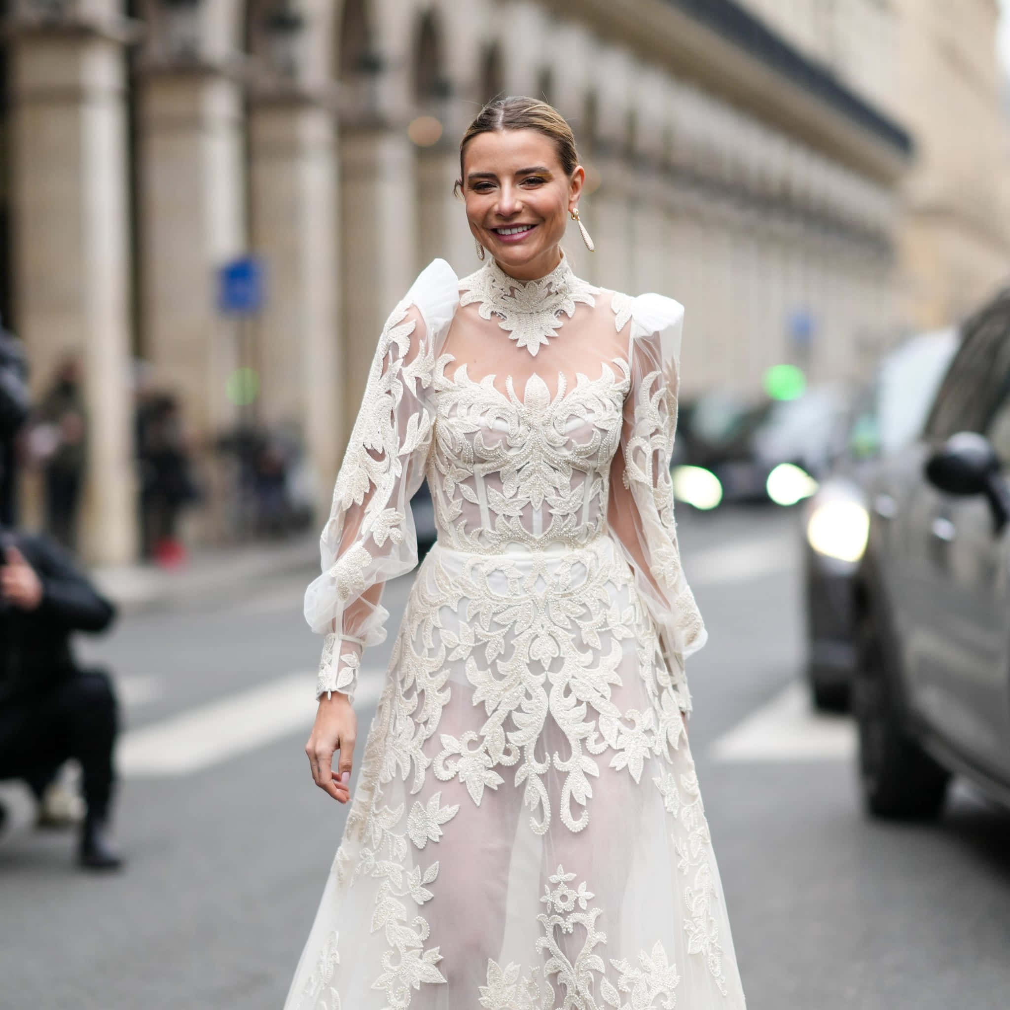 Bride's Dress 桌布 壁紙 — 一位身穿華麗白色蕾絲長裙的女性，自信地微笑著走在繁華的城市街道上。