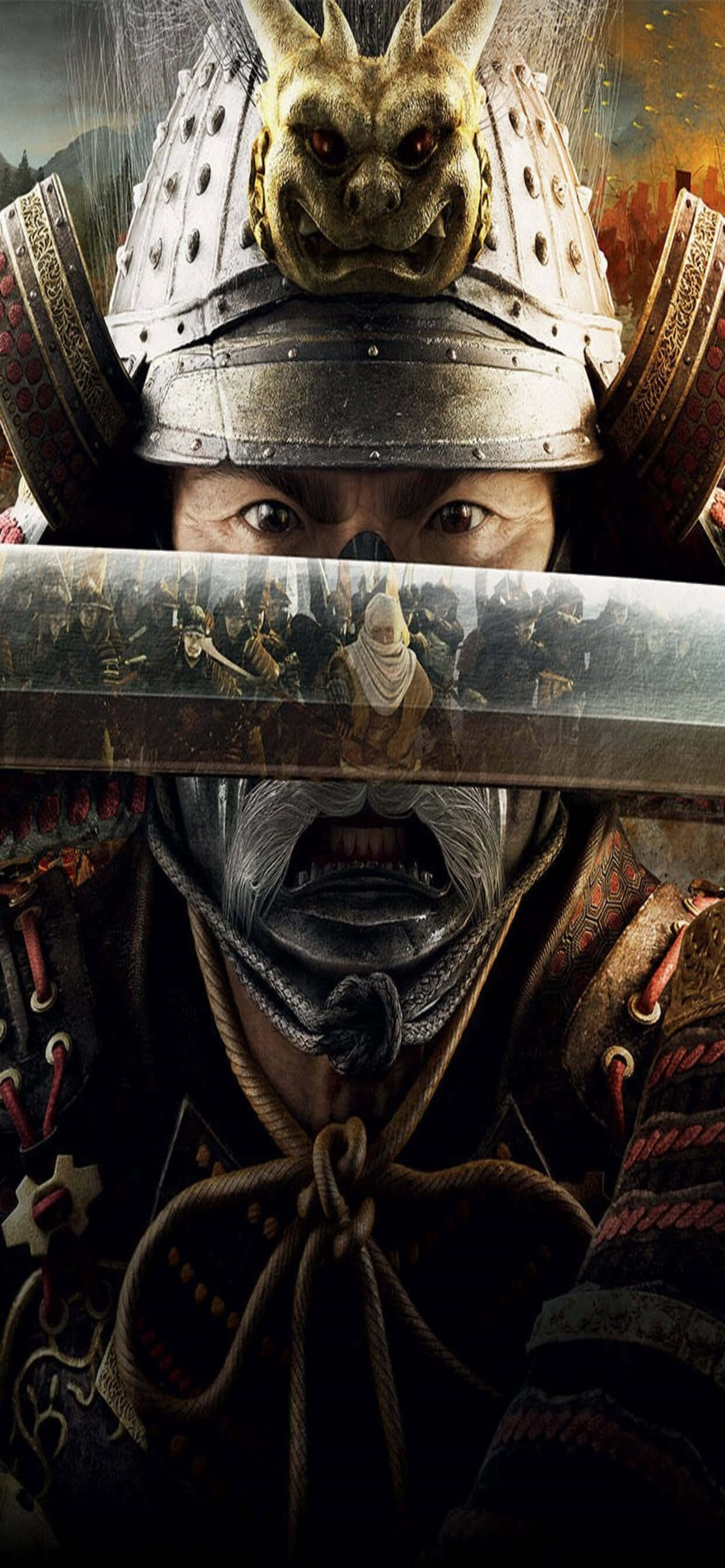 iPhone Xs Max Total War Shogun 2 桌布 壁紙 — 一位身穿華麗盔甲、戴著惡魔面具的武士，透過他的武士刀刀鋒凝視，反射出戰場場景。