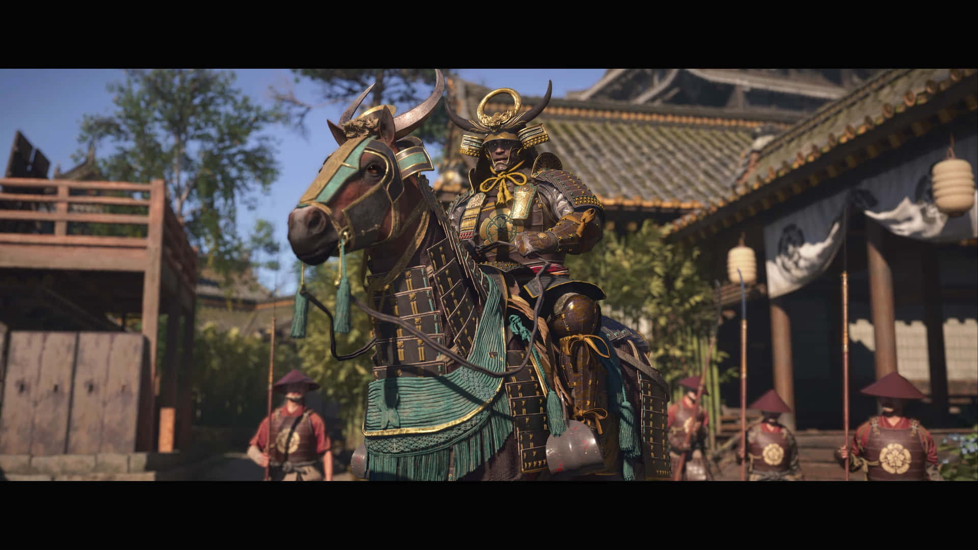 Assassin's Creed shadows 壁紙 — 一位身穿華麗金色和藍綠色盔甲的武士，騎著一匹同樣披甲的馬，穿過陽光明媚的傳統日本村莊街道。