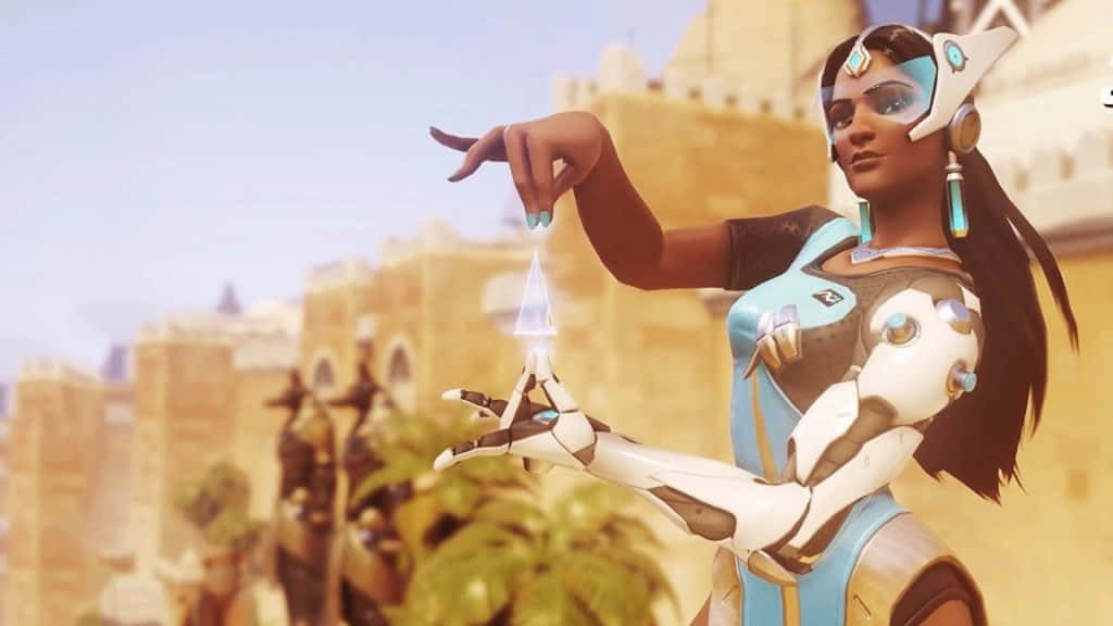 Overwatch Symmetra 桌布 壁紙 — 一位身穿藍白裝甲的未來戰士，在陽光普照的沙漠城市背景下，雙手之間引導著發光的能量。