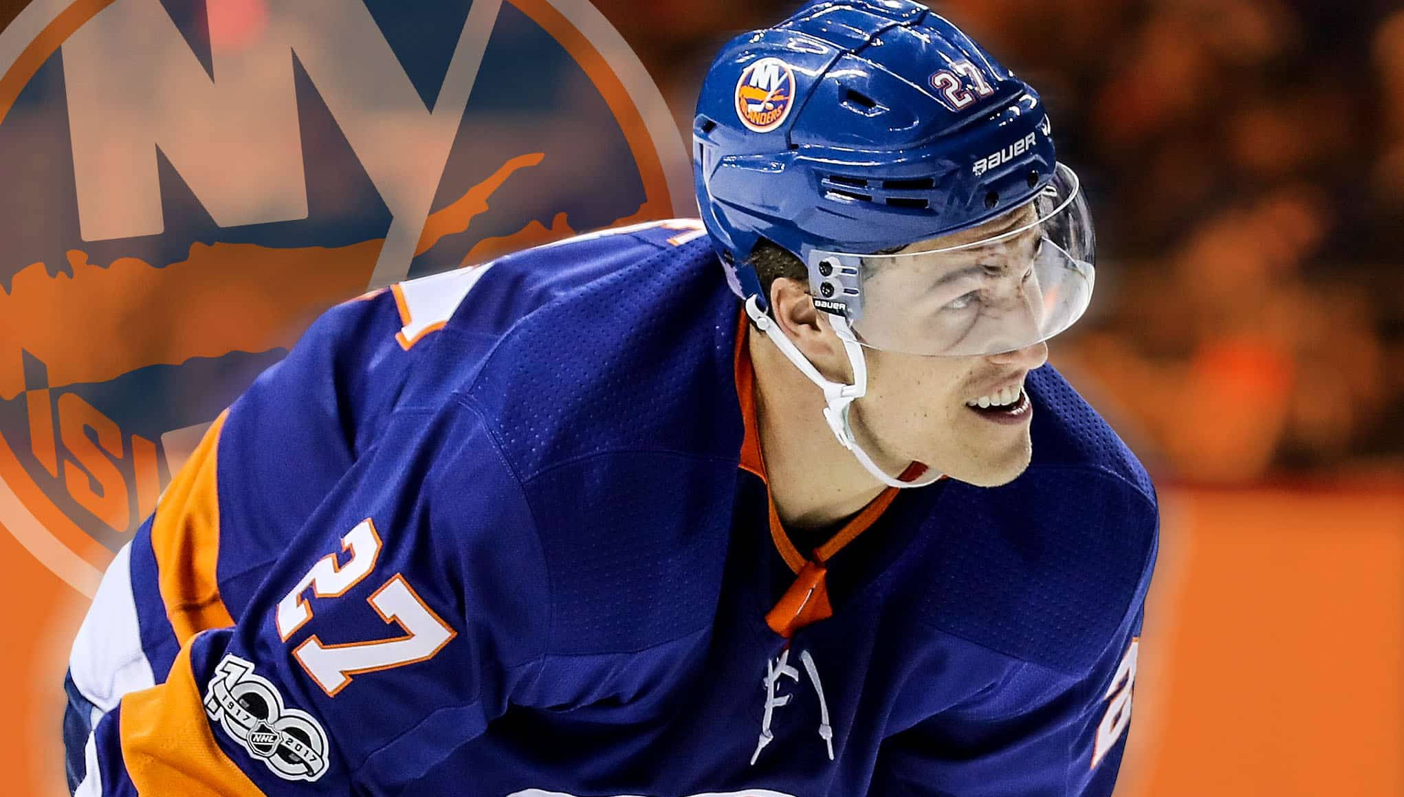 New York Islanders 桌布 壁紙 — 一位身穿藍色和橙色裝備的紐約島人冰球球員在比賽中露出燦爛笑容，身後是模糊的場館燈光。