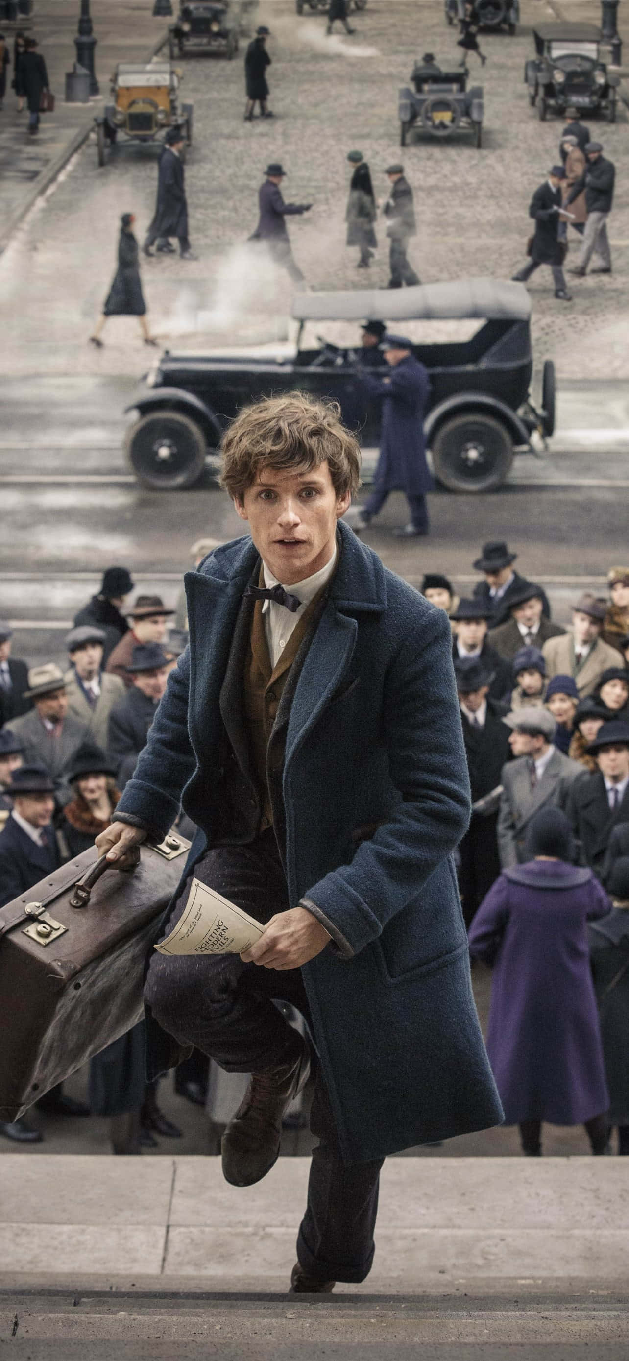 Fantastic Beasts 桌布 壁紙 — 一位身穿藍色外套的年輕男子跳下階梯，復古汽車和人群在繁忙的1920年代街景中穿梭而過。
