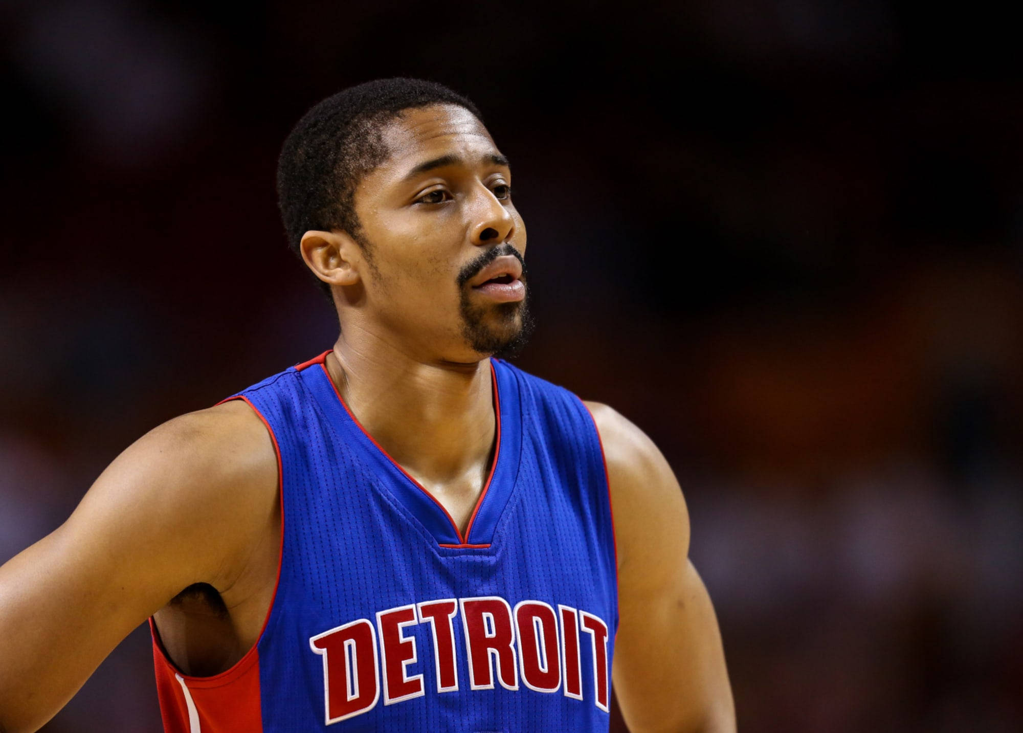 spencer dinwiddie 桌布 壁紙 — 一位身穿藍色底特律球衣的專注籃球運動員在場館燈光下於比賽中專注地凝視。