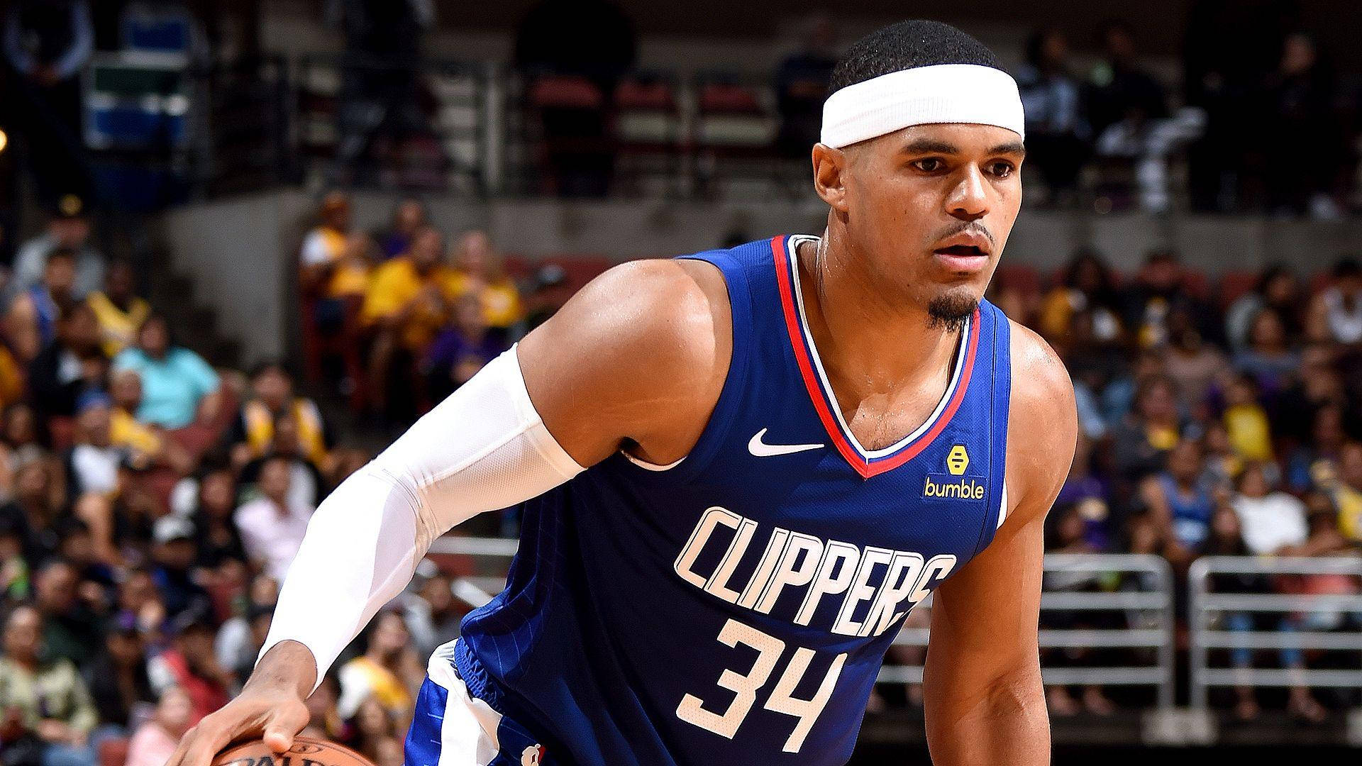 NBA 桌布 壁紙 — 一位身穿藍色快艇隊球衣的專注籃球運動員，在明亮的場館燈光下於激烈的比賽中運球。