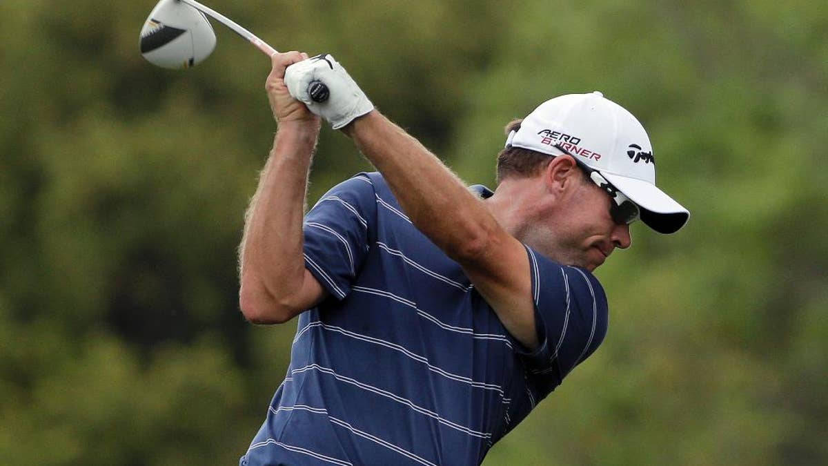 Stripes 桌布 壁紙 — 一位身穿藍色條紋襯衫和白色帽子的男性高爾夫球手，在模糊的綠色背景下，專注地揮動球桿。
