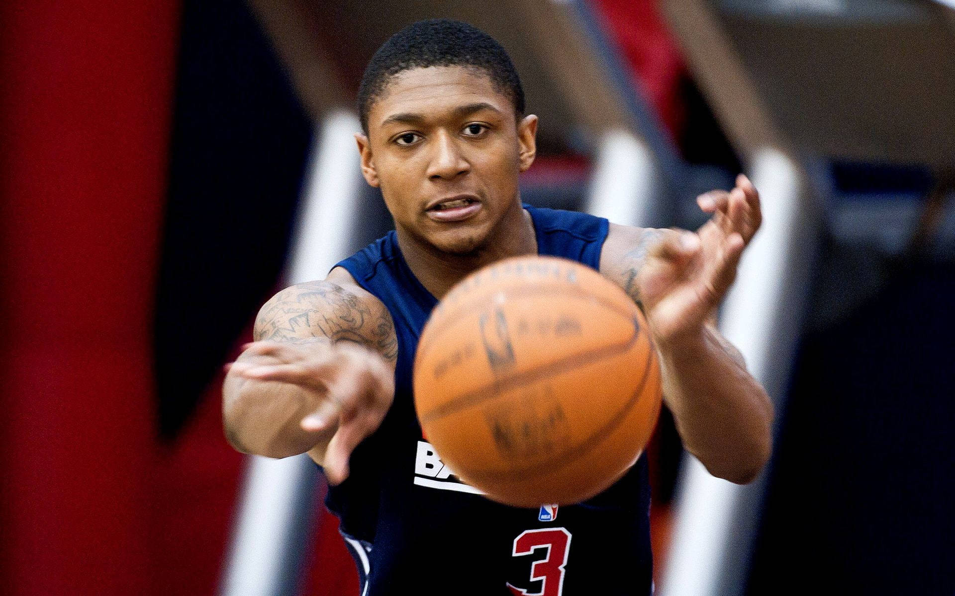 Wizards 桌布 壁紙 — 一位身穿藍色球衣、專注的籃球運動員在明亮的場館燈光下，於激烈的比賽中準備傳球。