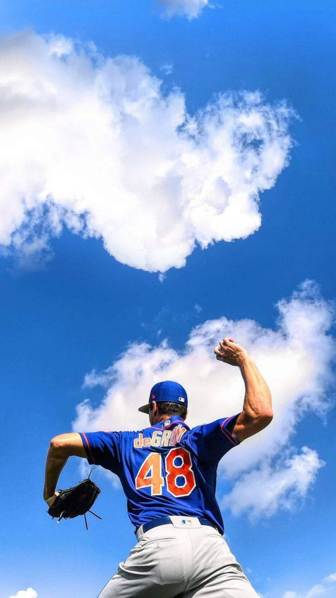 Degrom 桌布 壁紙 — 一位身穿藍色球衣、背號48的棒球投手，在明亮的藍天下，對著上方的心形雲朵準備投球。