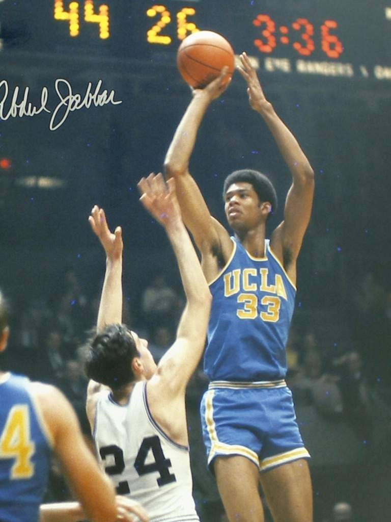 Kareem 桌布 壁紙 — 一位身穿藍色球衣33號的UCLA籃球運動員跳起投籃，而身穿白色球衣24號的防守球員試圖封阻。