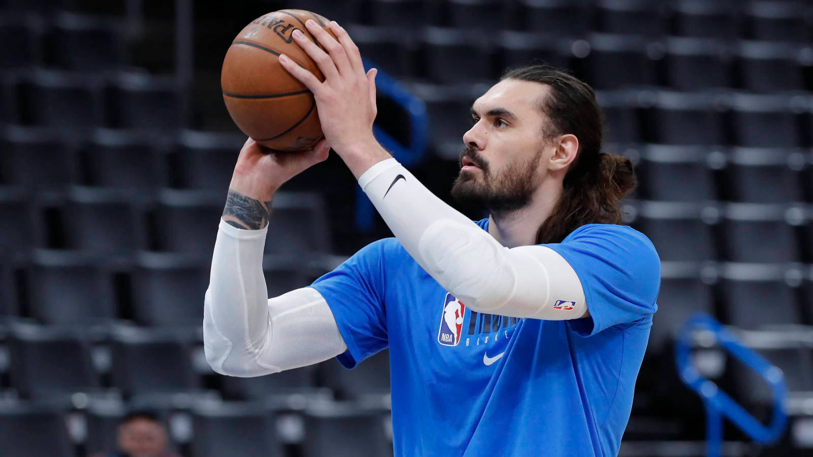 Steven Adams 桌布 壁紙 — 一位身穿藍色球衣的籃球運動員在空蕩蕩的球場上專注地準備投籃。