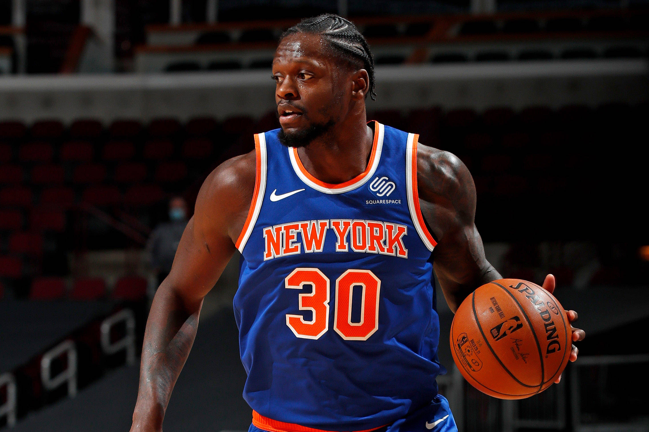 NBA 桌布 壁紙 — 一位身穿藍色紐約球衣、背號30的專注籃球運動員，在場館燈光下運著橙色Spalding籃球。
