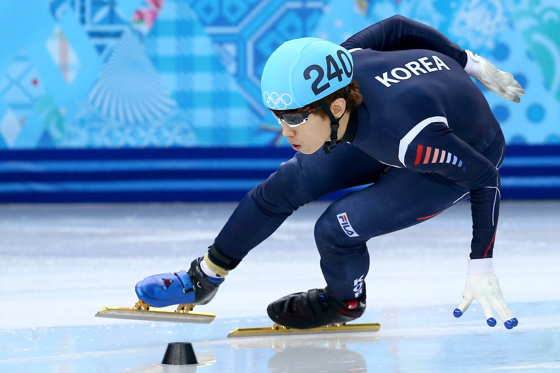 Olympics 桌布 壁紙 — 一位身穿藍色裝備的韓國競速滑冰選手在比賽中於冰場上傾身過彎。
