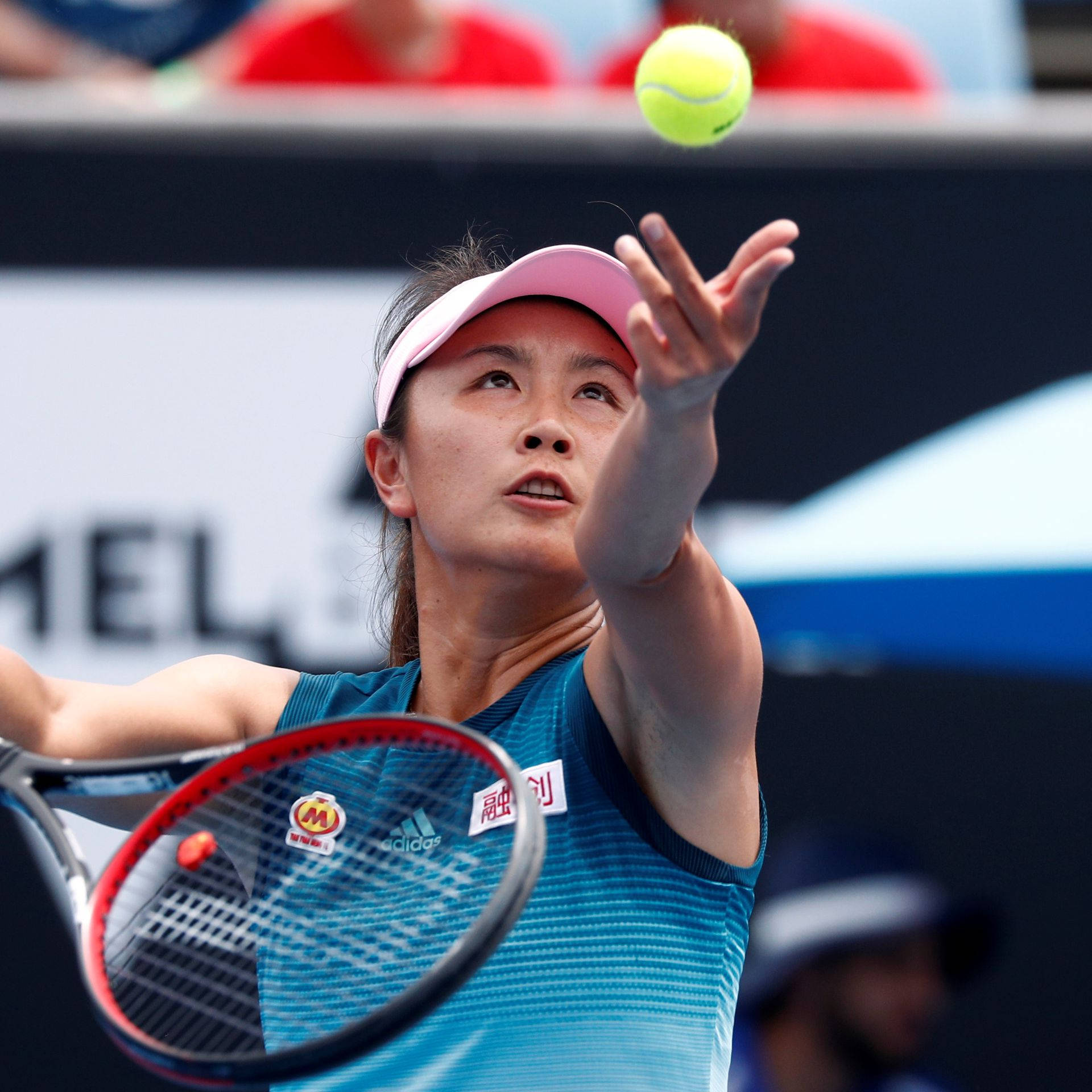 運動 桌布 壁紙 — 一位身穿藍色襯衫和粉紅色遮陽帽的女網球運動員在比賽中將明亮的黃色網球高高拋起準備發球。