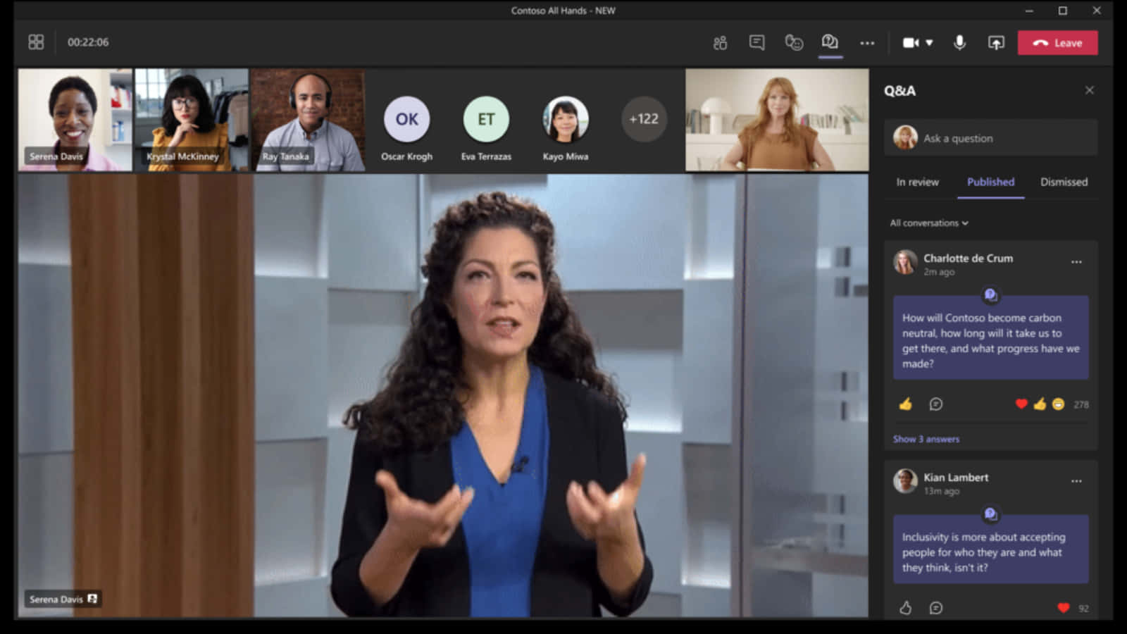 Microsoft Teams 桌布 壁紙 — 一位身穿藍色襯衫和黑色西裝外套的女性在虛擬會議通話中生動地說話，多個參與者以網格佈局顯示。