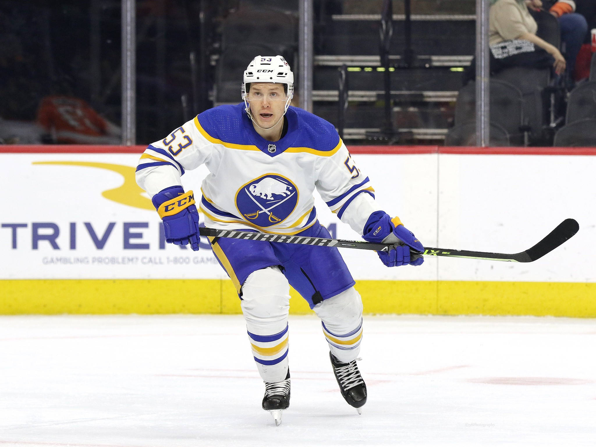 hockey 桌布 壁紙 — 一位身穿藍金球衣的布法羅軍刀冰球球員，帶著專注的表情在冰上激烈滑行。