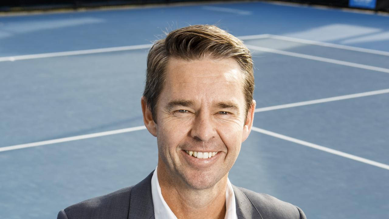 Tennis 桌布 壁紙 — 一位身穿西裝、面帶微笑的男子自信地站在藍色網球場上，球場上有清晰的白色線條，在明亮的日光下。