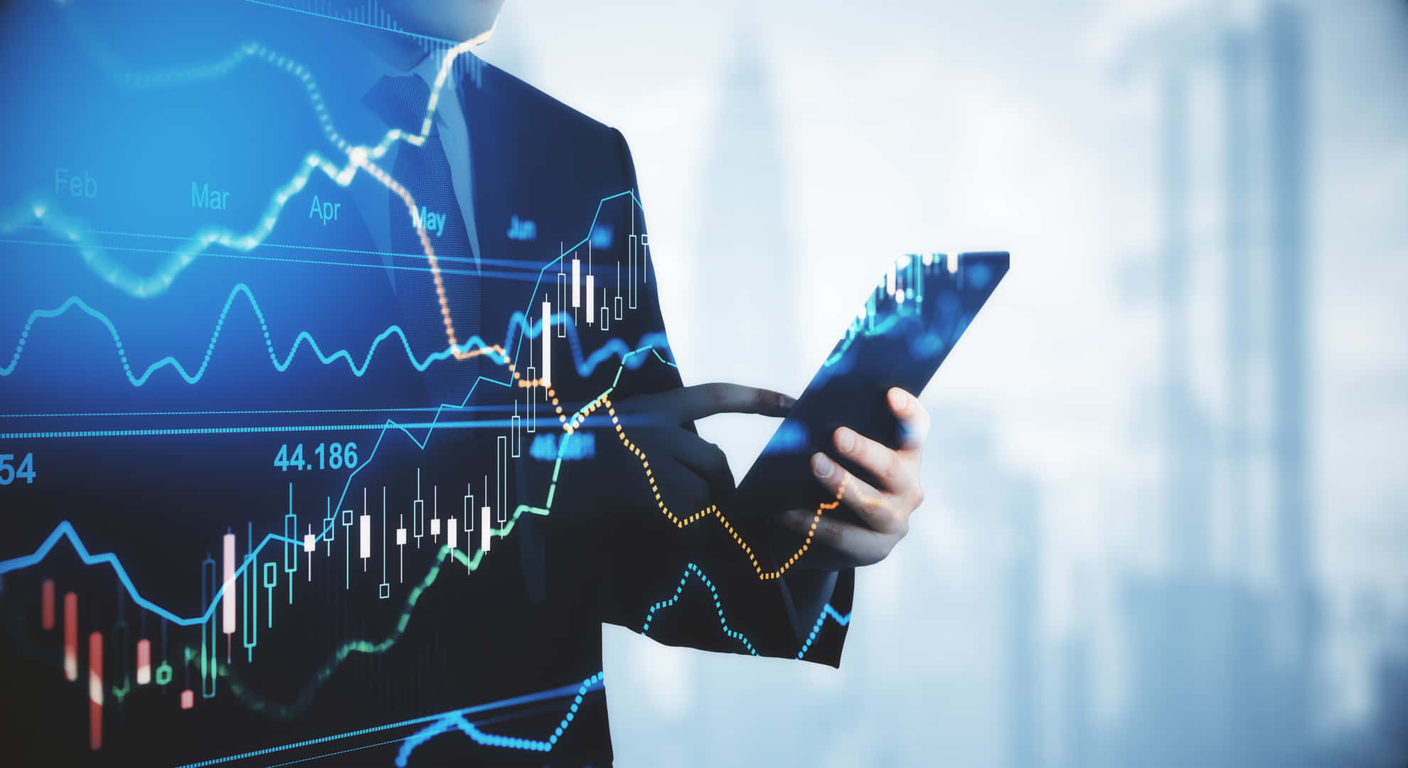 Investment 桌布 壁紙 — 一位身穿西裝的商人手持平板電腦，發光的金融圖表和圖形疊加在他的身體上，背景是模糊的城市景觀。
