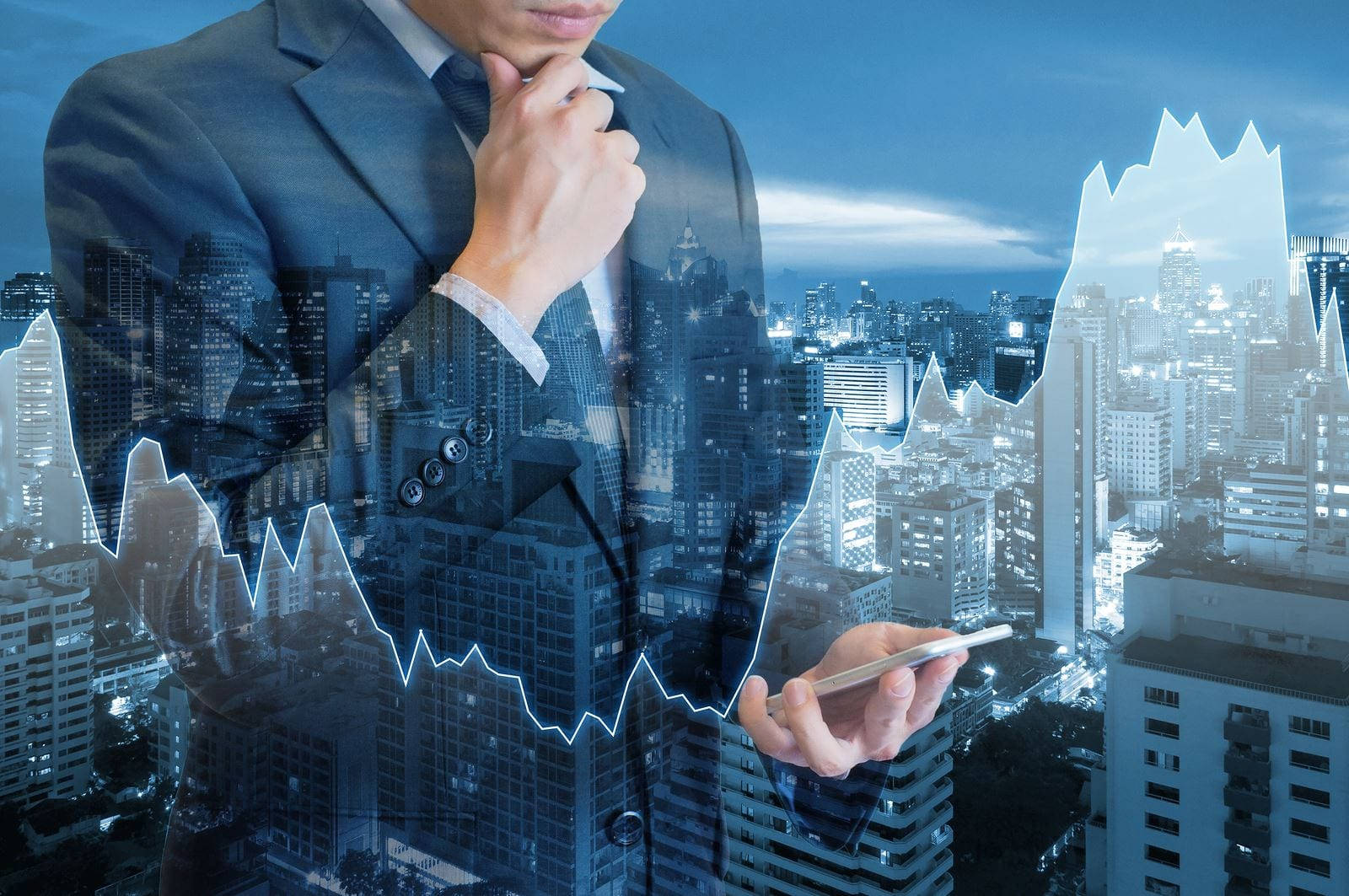 Business 桌布 壁紙 — 一位身穿西裝的商人手持電話，發光的股票圖表覆蓋他的身體，背景是夜間城市景觀。