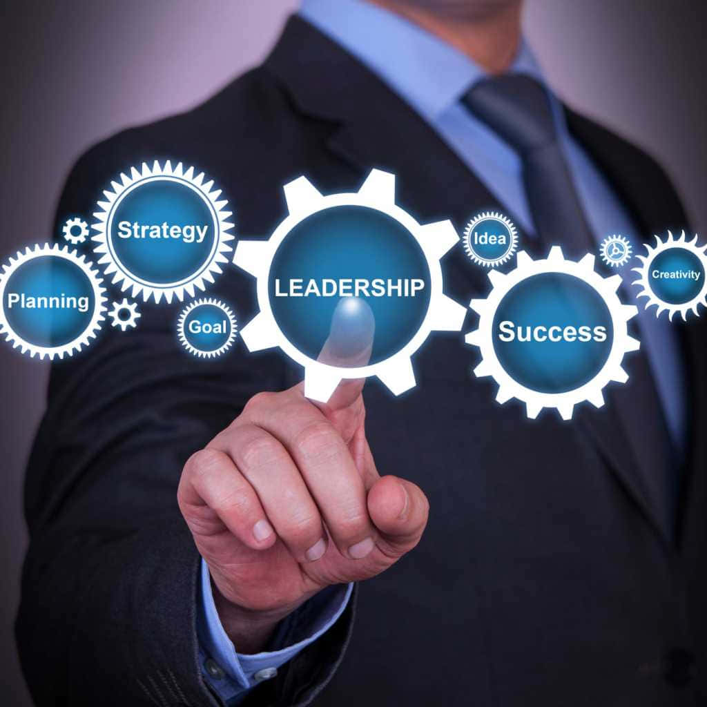 Leadership 桌布 壁紙 — 一位身穿西裝的商人與標有領導策略和成功的發光數位齒輪互動。
