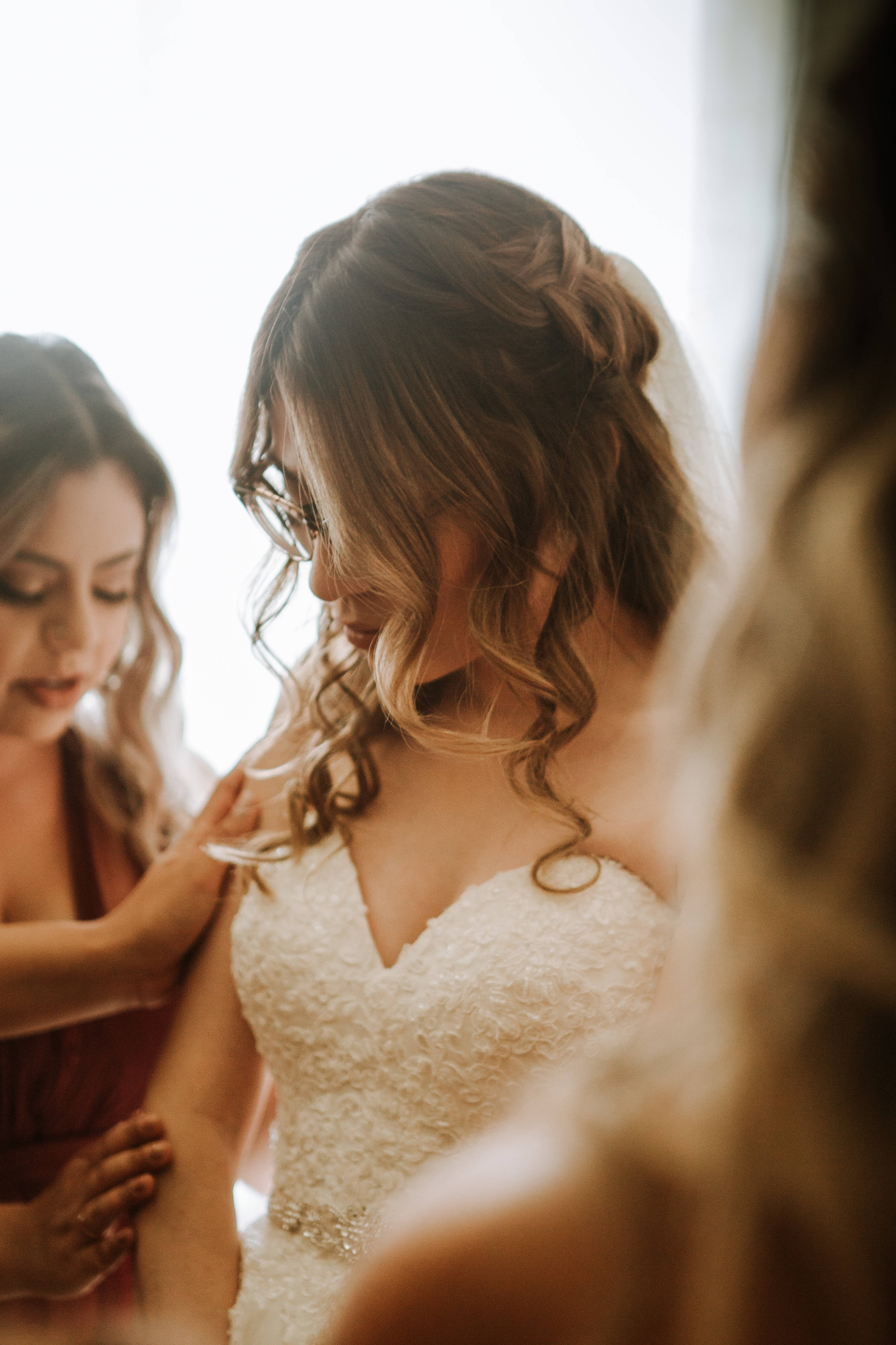 Bridesmaids 桌布 壁紙 — 一位身穿質感白色婚紗、髮型精緻的新娘，在溫暖的室內環境中由伴娘們溫柔地協助。