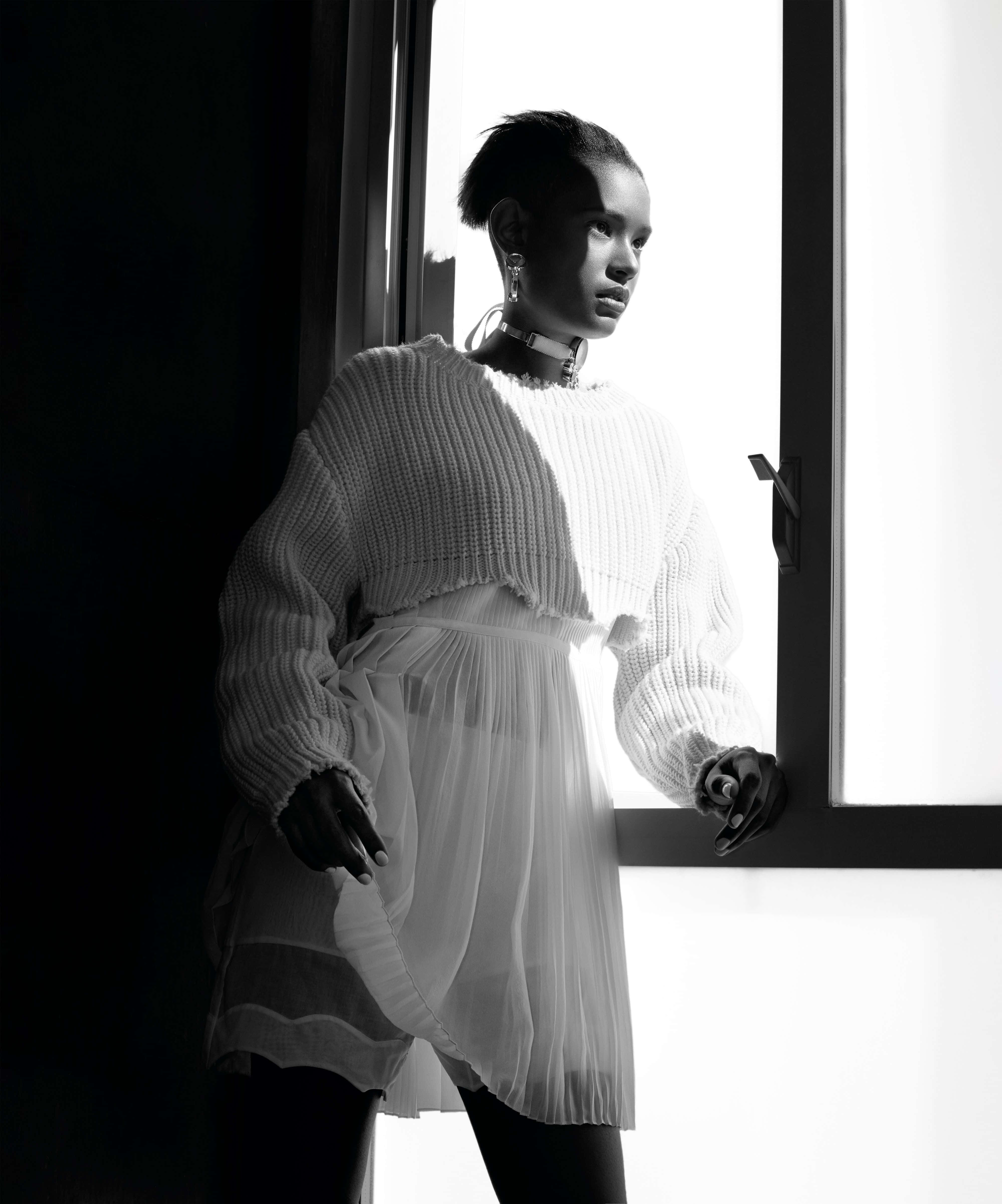 Black And White Fashion 桌布 壁紙 — 一位身穿質感白色毛衣和透視裙的女性，在明亮的窗光下以剪影呈現的黑白照片。