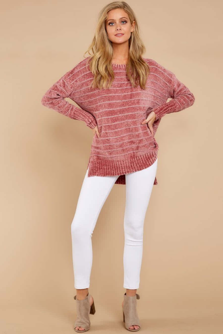 Pink Sweater 桌布 壁紙 — 一位身穿質感粉色毛衣和白色褲子的女性，在米色攝影棚背景前自信地擺姿勢。