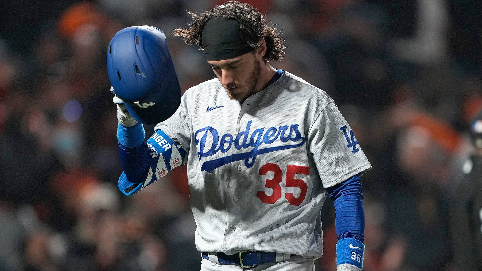Cody 桌布 壁紙 — 一位身穿道奇隊35號球衣的棒球選手在夜間球場低舉頭盔，低頭注視。