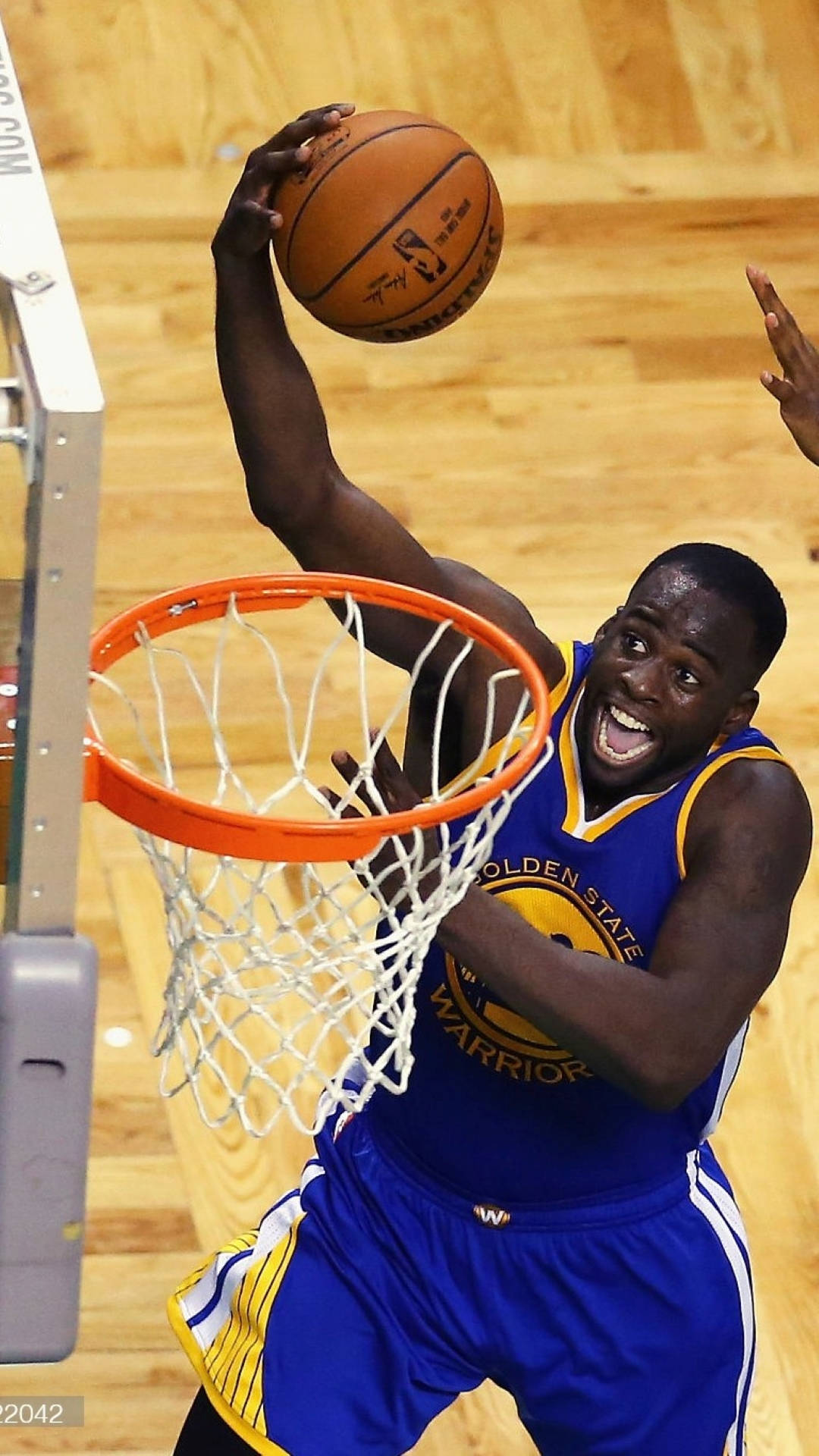 Draymond Green 桌布 壁紙 — 一位身穿金州勇士隊球衣的籃球運動員在比賽中帶著強烈的專注和力量灌籃。