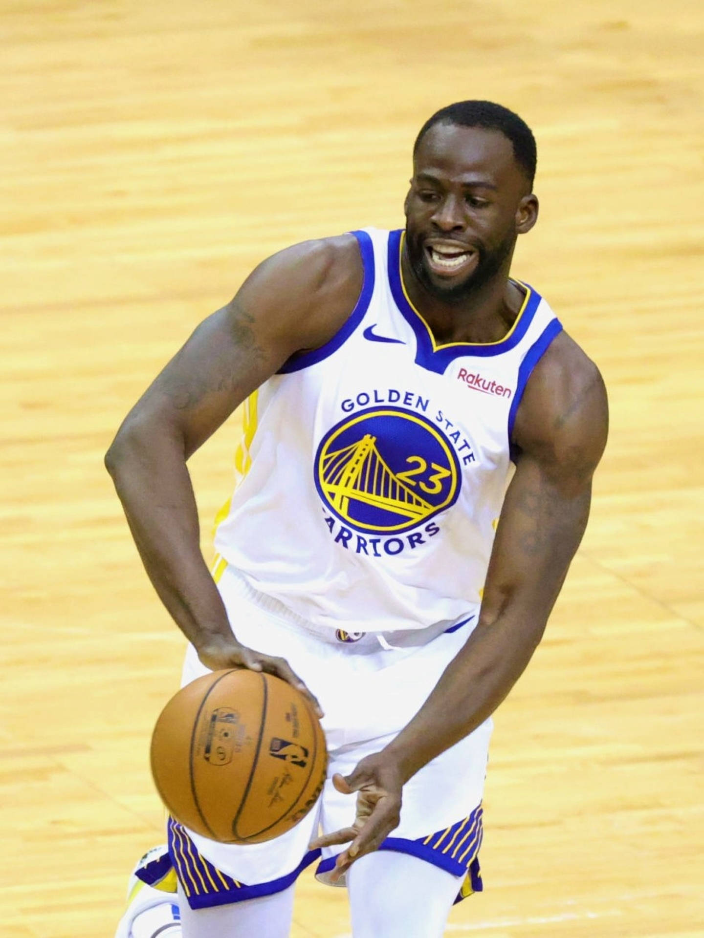 Draymond Green 桌布 壁紙 — 一位身穿金州勇士隊球衣的籃球運動員在拋光木地板上專注地運球。
