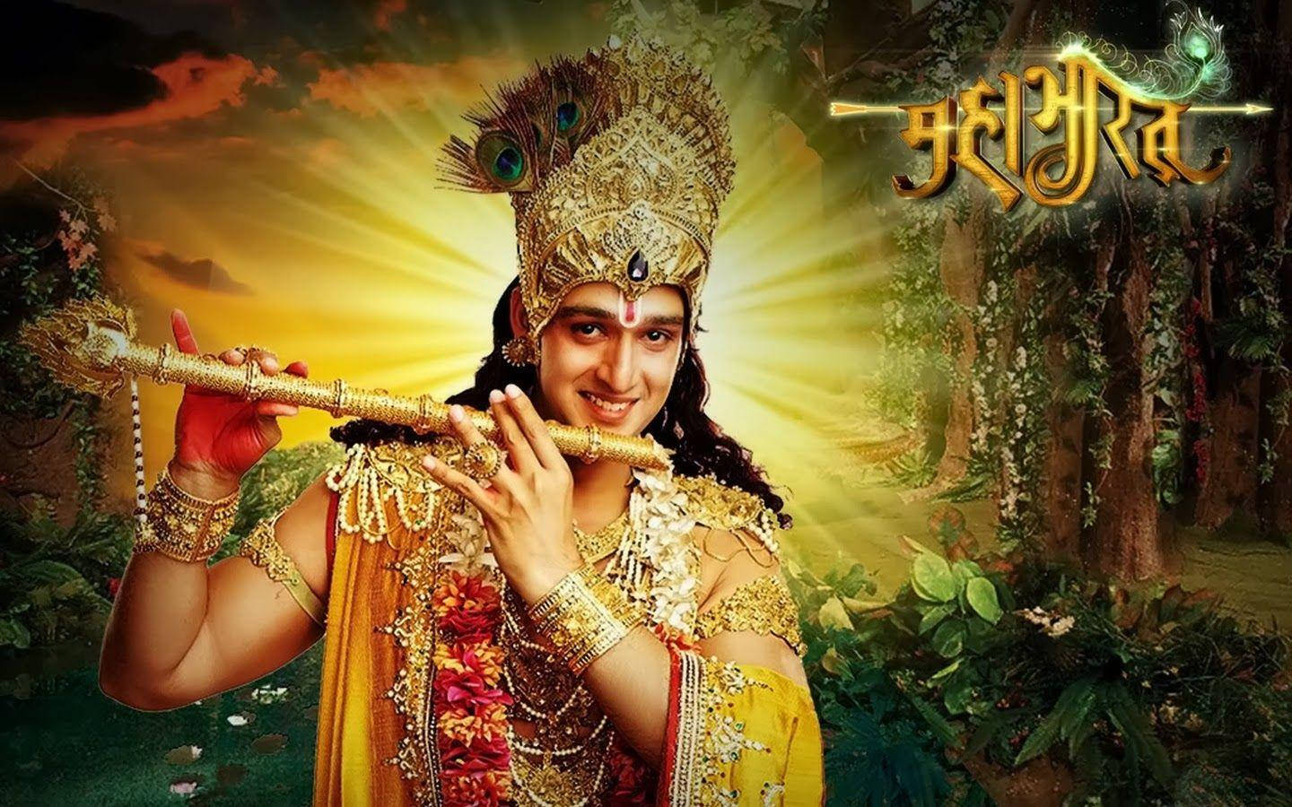 Mahabharat Krishna 桌布 壁紙 — 一位身穿金色華服、光芒四射的神祇在日落時分，於閃爍的叢林樹葉間吹奏長笛。