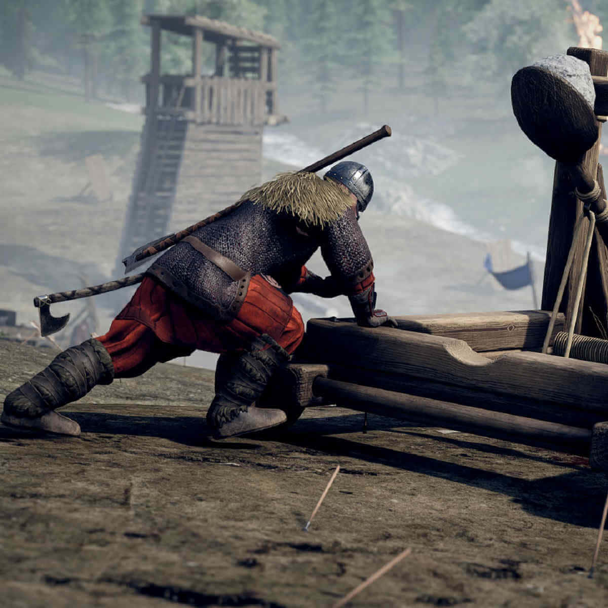 Mordhau 桌布 壁紙 — 一位身穿鎖子甲和紅色褲子的中世紀戰士，在迷霧森林的空地上費力地裝載一個巨大的木製投石機。