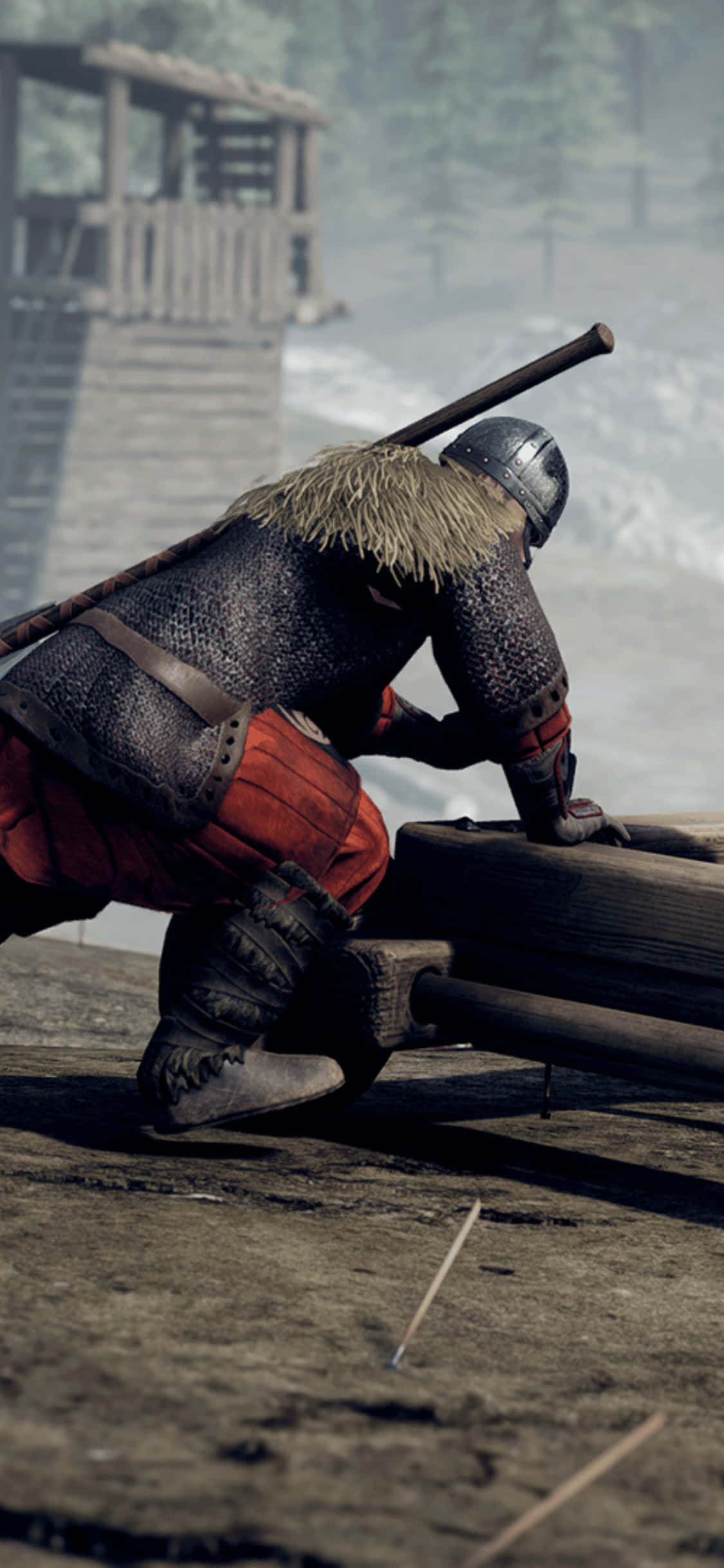 iPhone Xs Mordhau 桌布 壁紙 — 一位身穿鎖子甲和頭盔的中世紀騎士跪在泥濘戰場上的木製攻城器械旁，背景中有一座木塔籠罩在迷霧中。