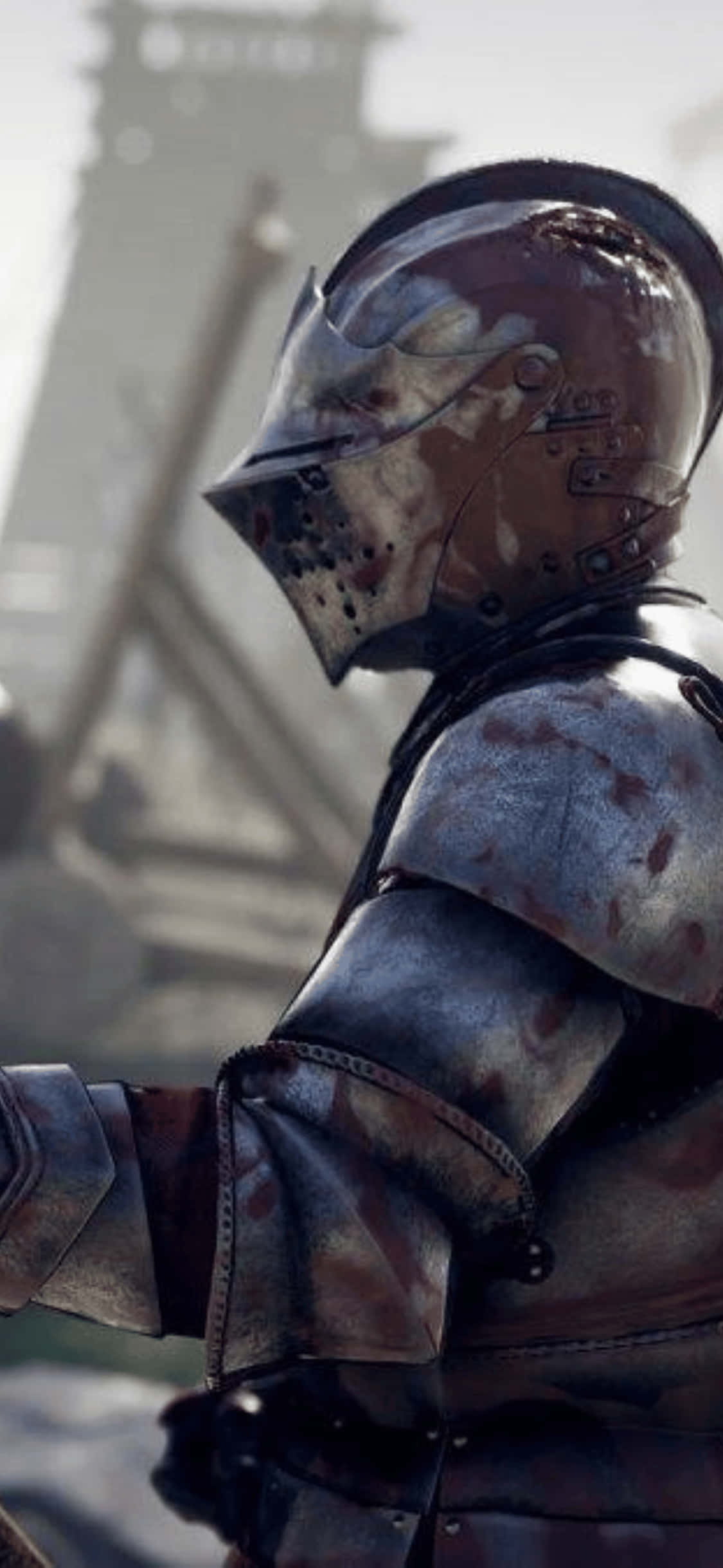iPhone Xs Mordhau 桌布 壁紙 — 一位身穿鏽蝕盔甲的風化騎士，站在荒涼的廢墟中，遠處有一座塔樓，光線朦朧。