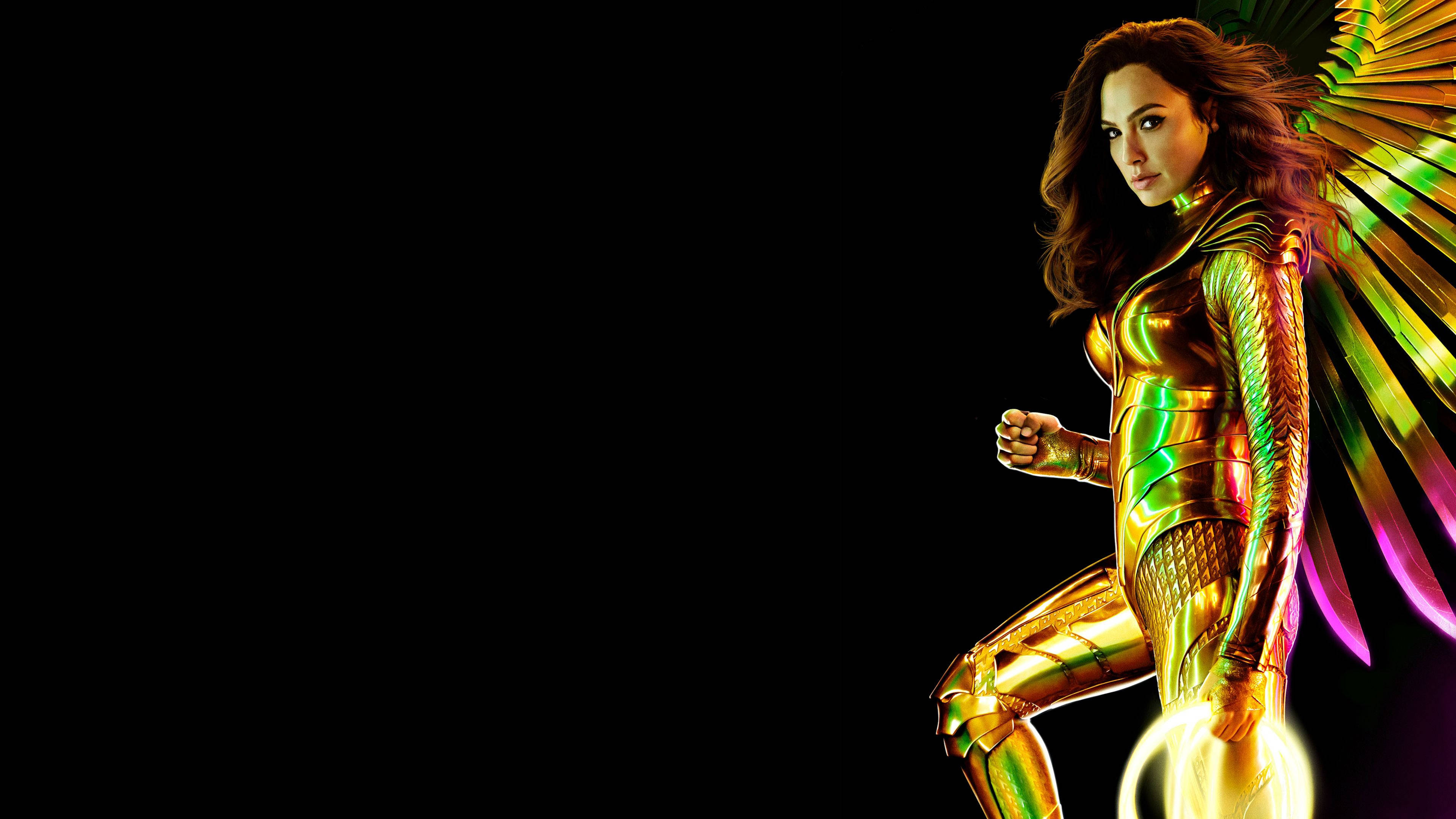 Wonder Woman 1984 桌布 壁紙 — 一位身穿閃爍金色套裝、擁有耀眼翅膀的女超級英雄，站在黑色背景前。