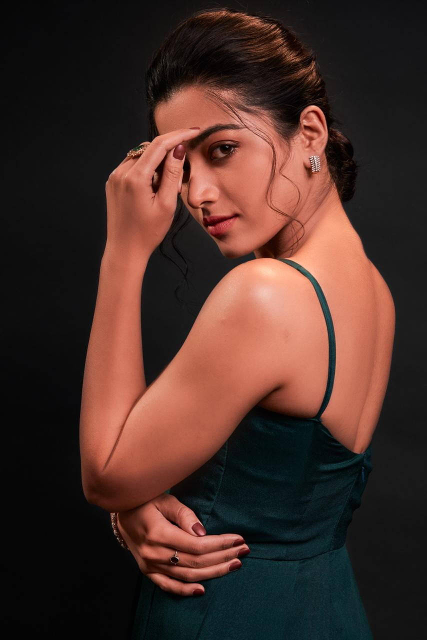 telugu 桌布 壁紙 — 一位身穿青綠色連衣裙的女性在黑色背景前擺姿勢，手靠近臉部，眼神自信。