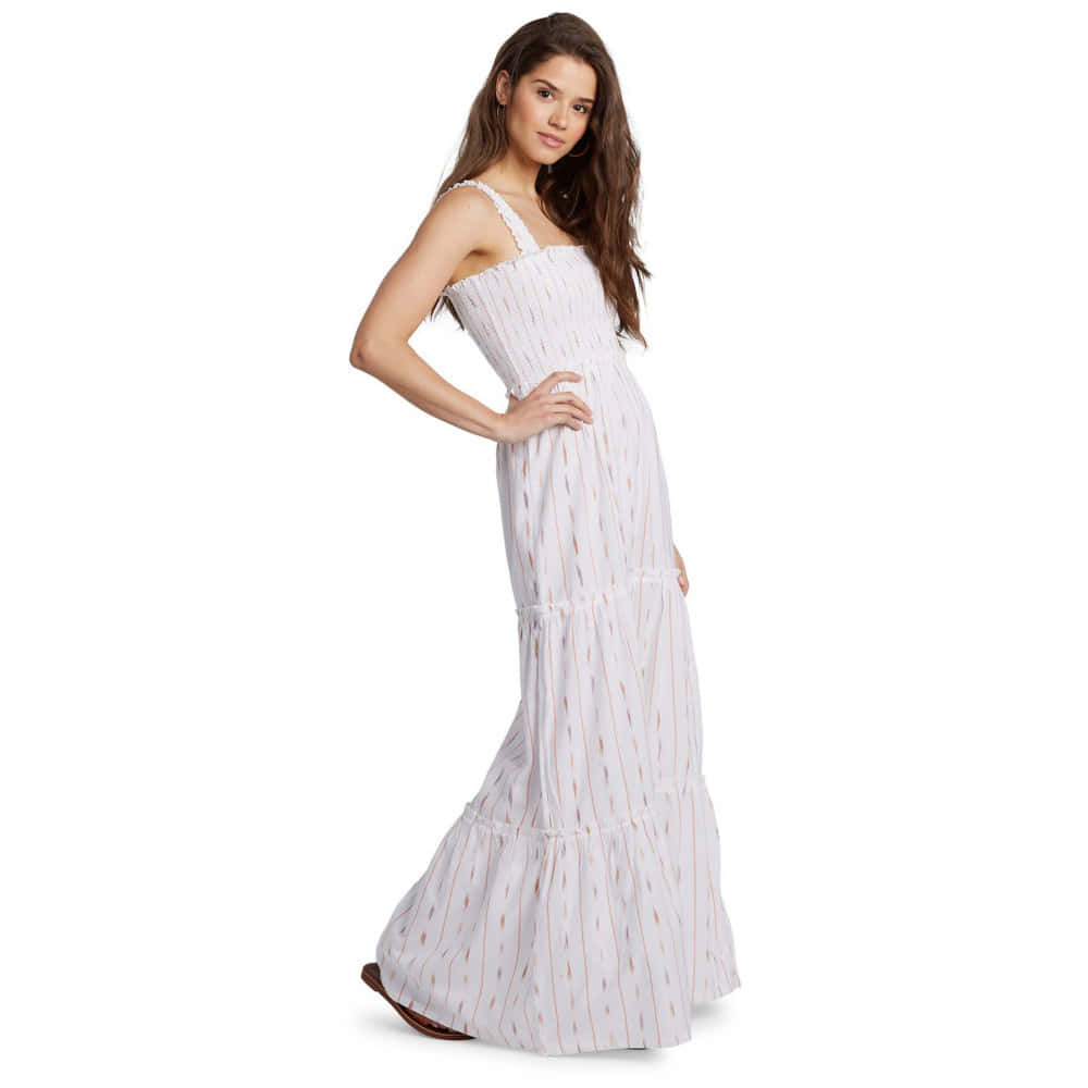 White Dress 桌布 壁紙 — 一位身穿飄逸白色圖案長裙的女性在純白背景前自信地擺姿勢。