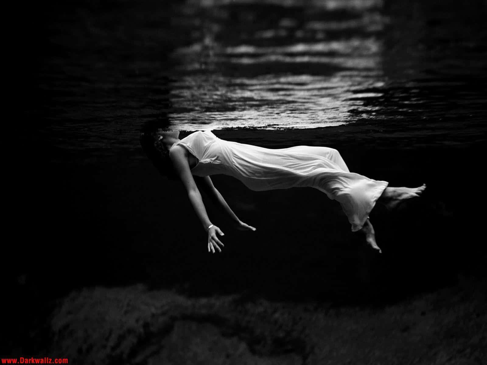 Depression Girl 桌布 壁紙 — 一位身穿飄逸白色連衣裙的女性，頭部露出水面，在水中寧靜地漂浮，呈現出鮮明的黑白構圖。