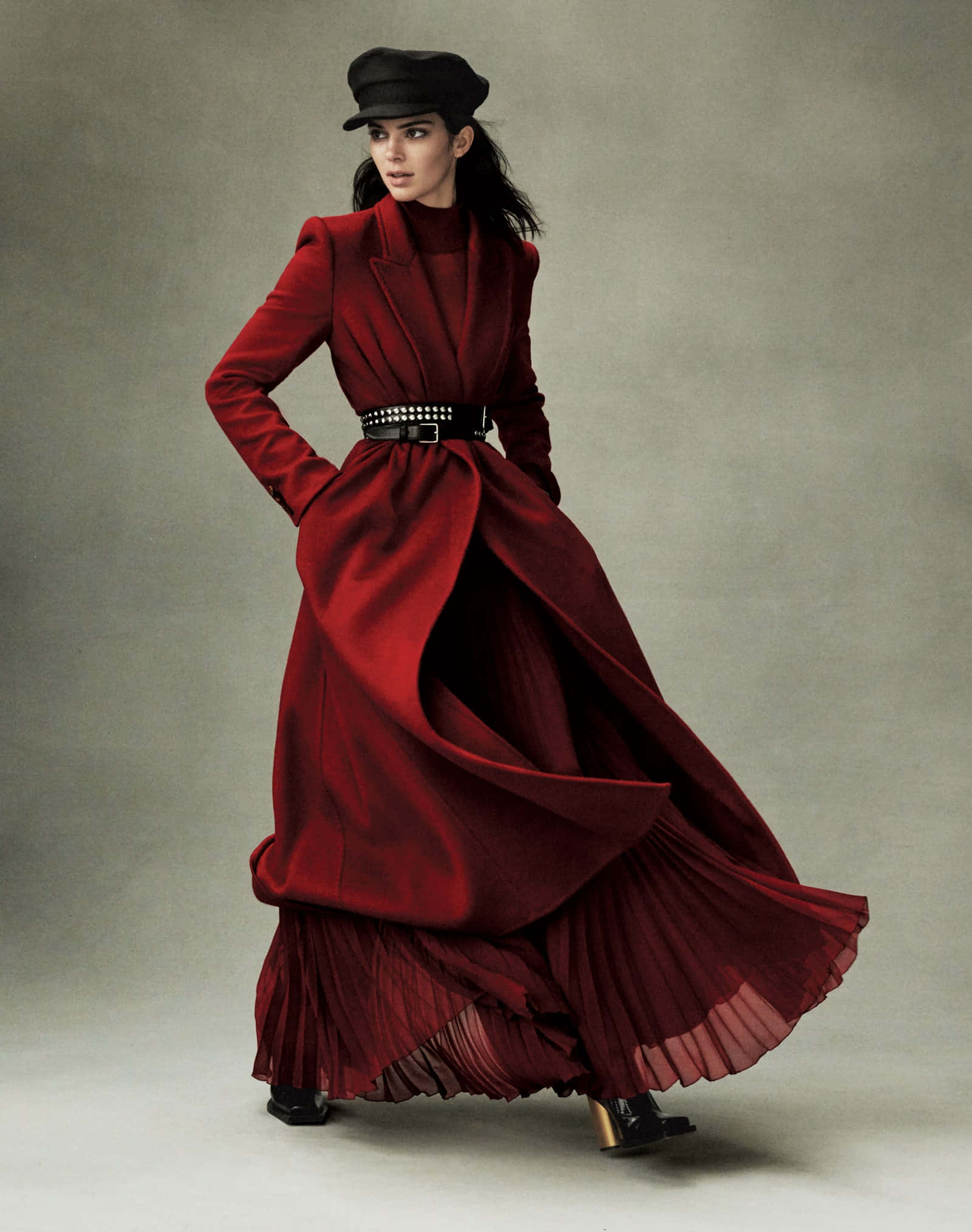 Red Clothing 桌布 壁紙 — 一位身穿飄逸紅色外套和黑色帽子的女性，在戲劇性燈光下，站在中性工作室背景前。