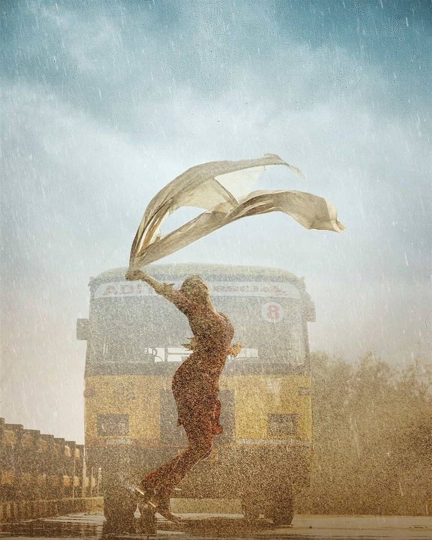 rain dance 桌布 壁紙 — 一位身穿飄逸紅裙的女子在滂沱大雨中快樂地跳舞，白色圍巾在她身後飄揚，背景是一輛黃色巴士。