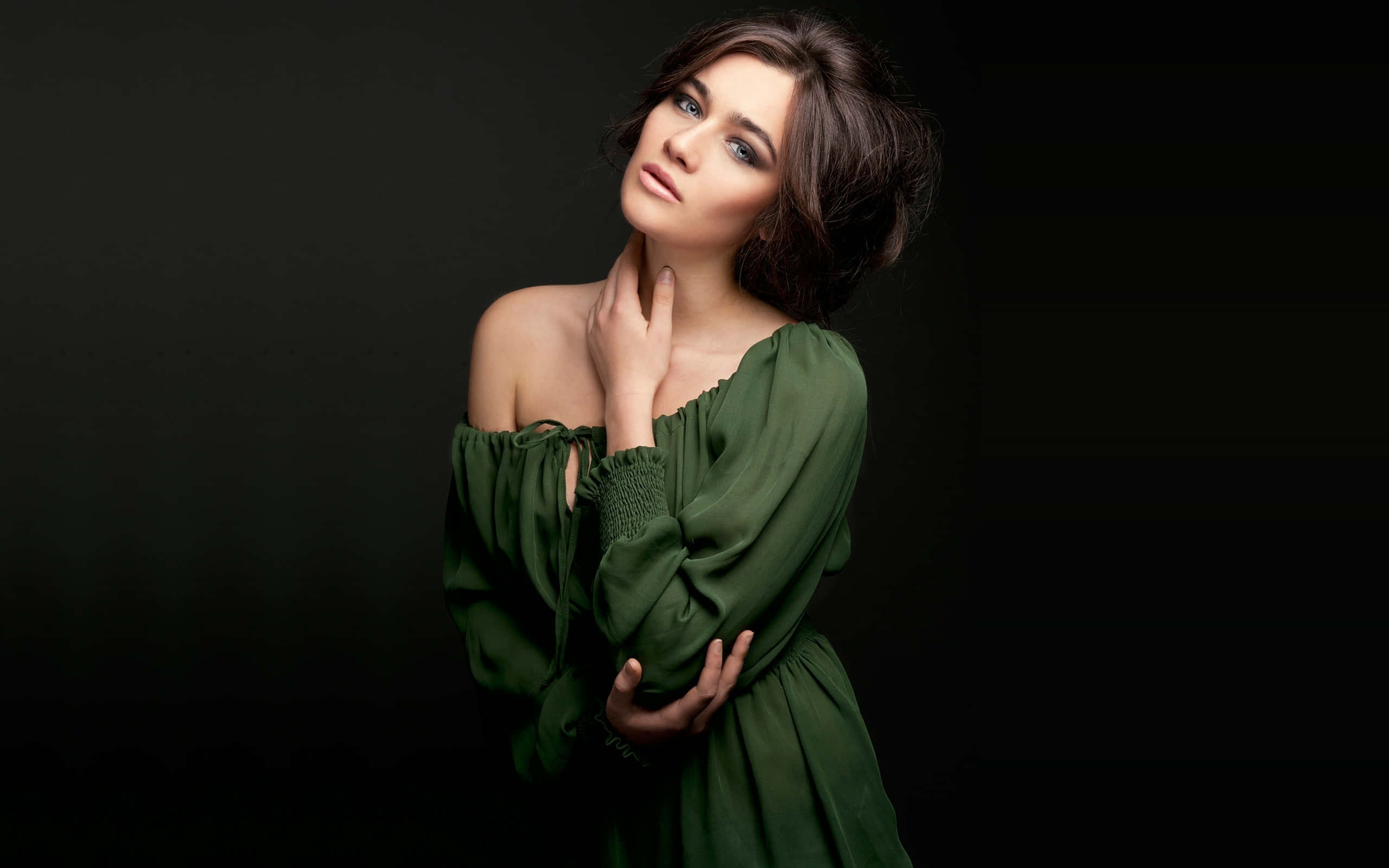 Photoshoot 桌布 壁紙 — 一位身穿飄逸綠色連衣裙的女性在柔和的攝影棚燈光下，在深色背景前優雅地擺姿勢。