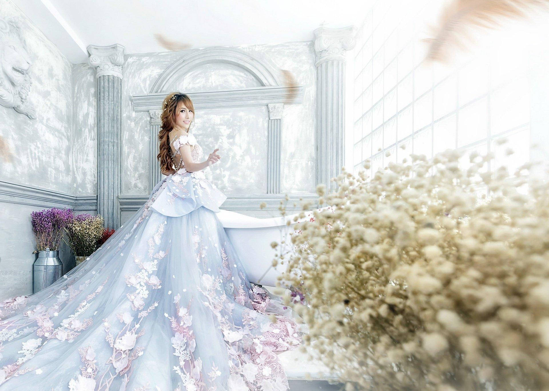 Bride 桌布 壁紙 — 一位身穿飄逸花卉長袍的女性，優雅地站在明亮華麗的浴室中，周圍有乾燥花和柔和的光線。