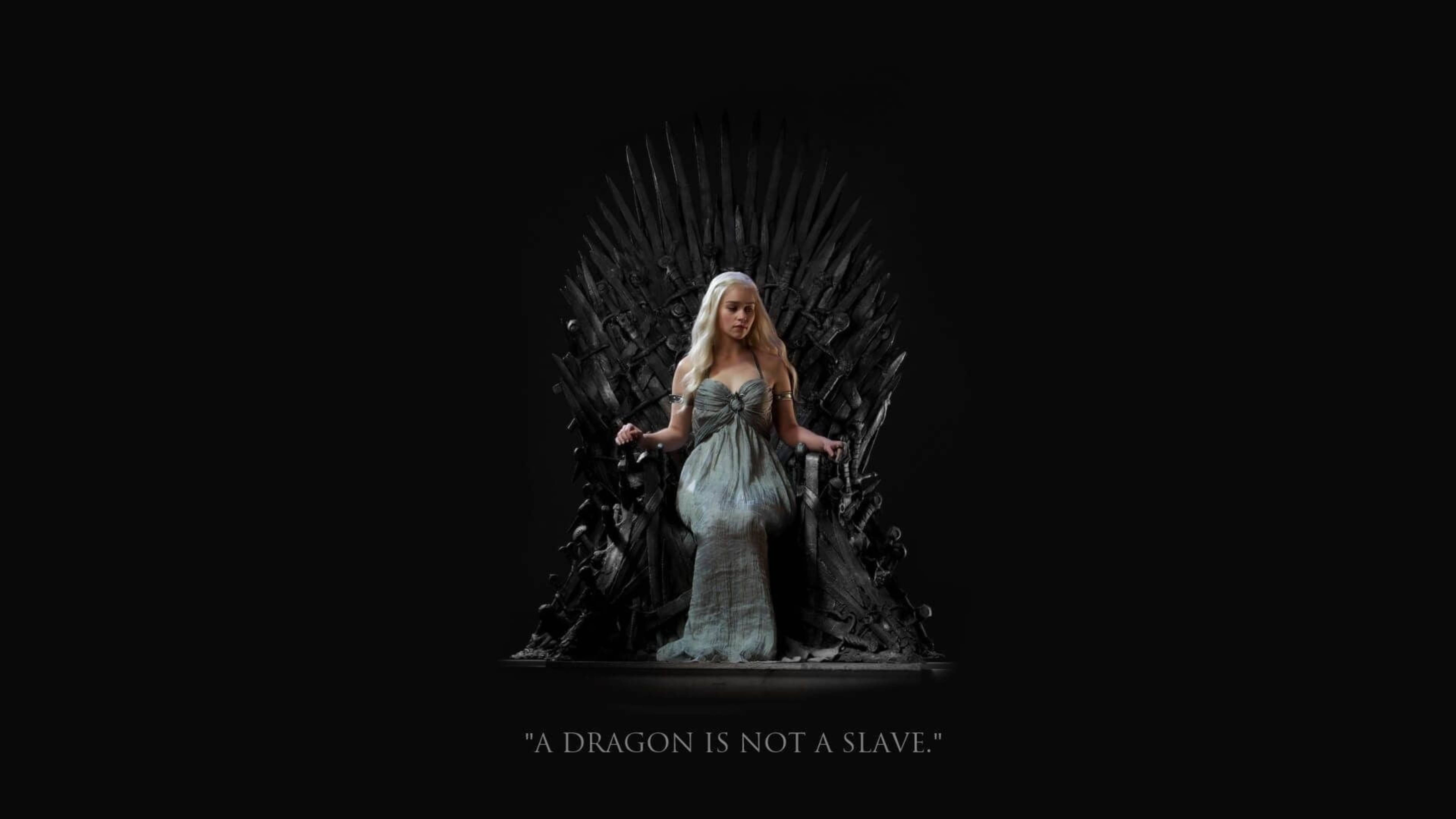 daenerys 桌布 壁紙 — 一位身穿飄逸銀色長裙的女性威嚴地坐在鐵王座上，背景是純黑色，下方有引文「龍不是奴隸」。