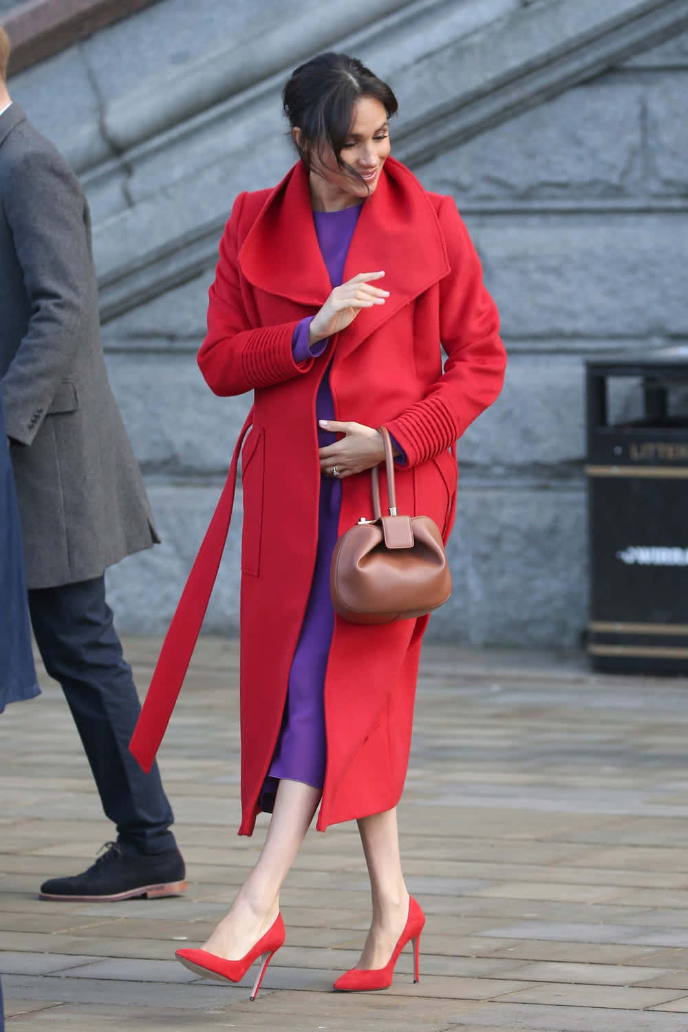 Red Coat 桌布 壁紙 — 一位身穿鮮紅色外套和相配高跟鞋的女性自信地走過石鋪的都市廣場。