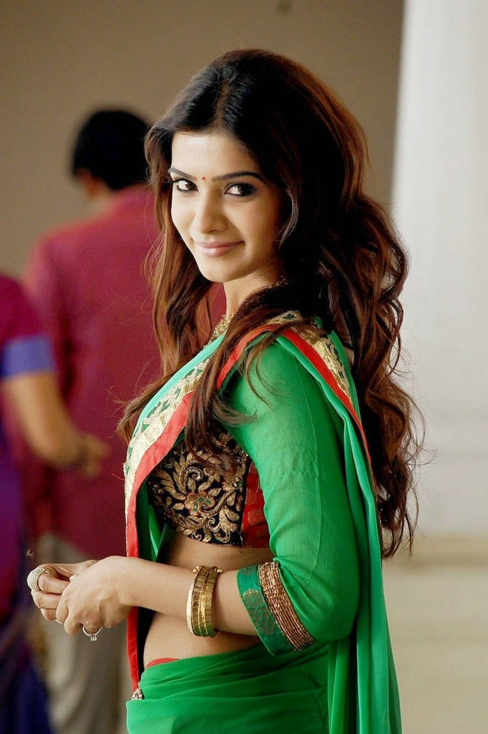 Samantha Saree 桌布 壁紙 — 一位身穿鮮豔綠色傳統服飾的女性，微笑著回頭看。