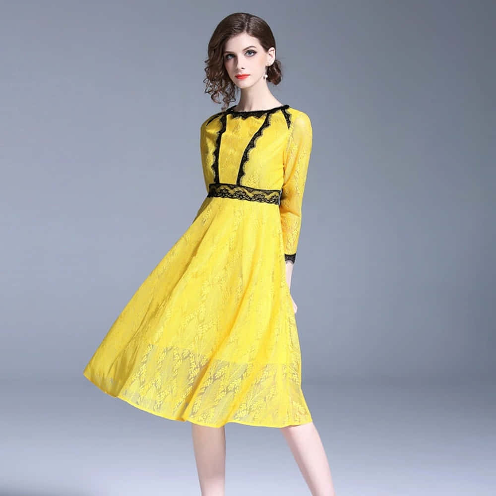 Yellow Fashion 桌布 壁紙 — 一位身穿鮮黃色蕾絲連衣裙、帶黑色飾邊的女性，在柔和的灰色工作室背景前優雅地擺姿勢。