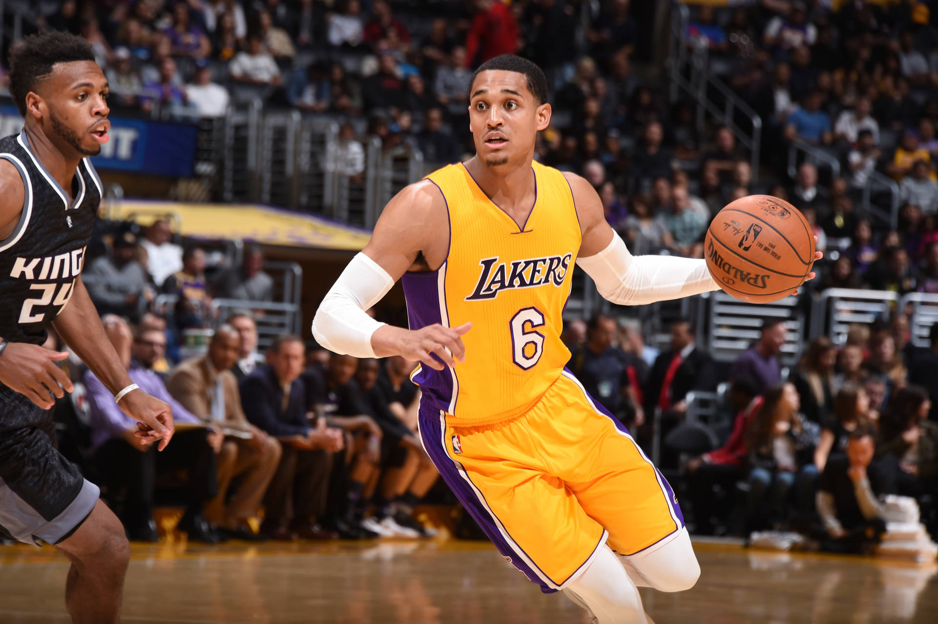 湖人籃球球員在比賽中運球越過國王防守者。 — NBA 壁紙