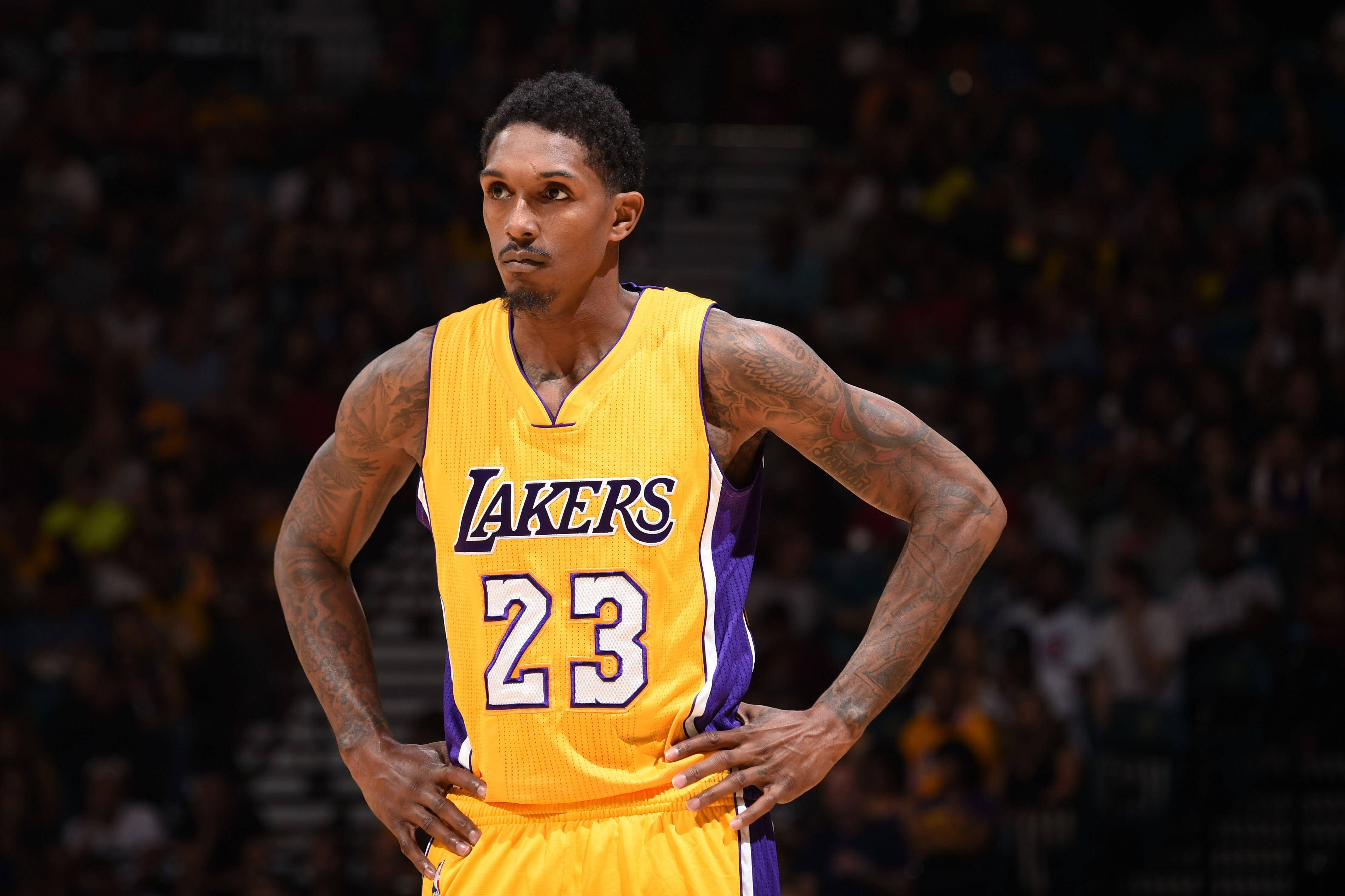 Lou Williams 桌布 壁紙 — 一位身穿黃色湖人隊23號球衣的專注籃球運動員，在比賽中雙手叉腰站立。
