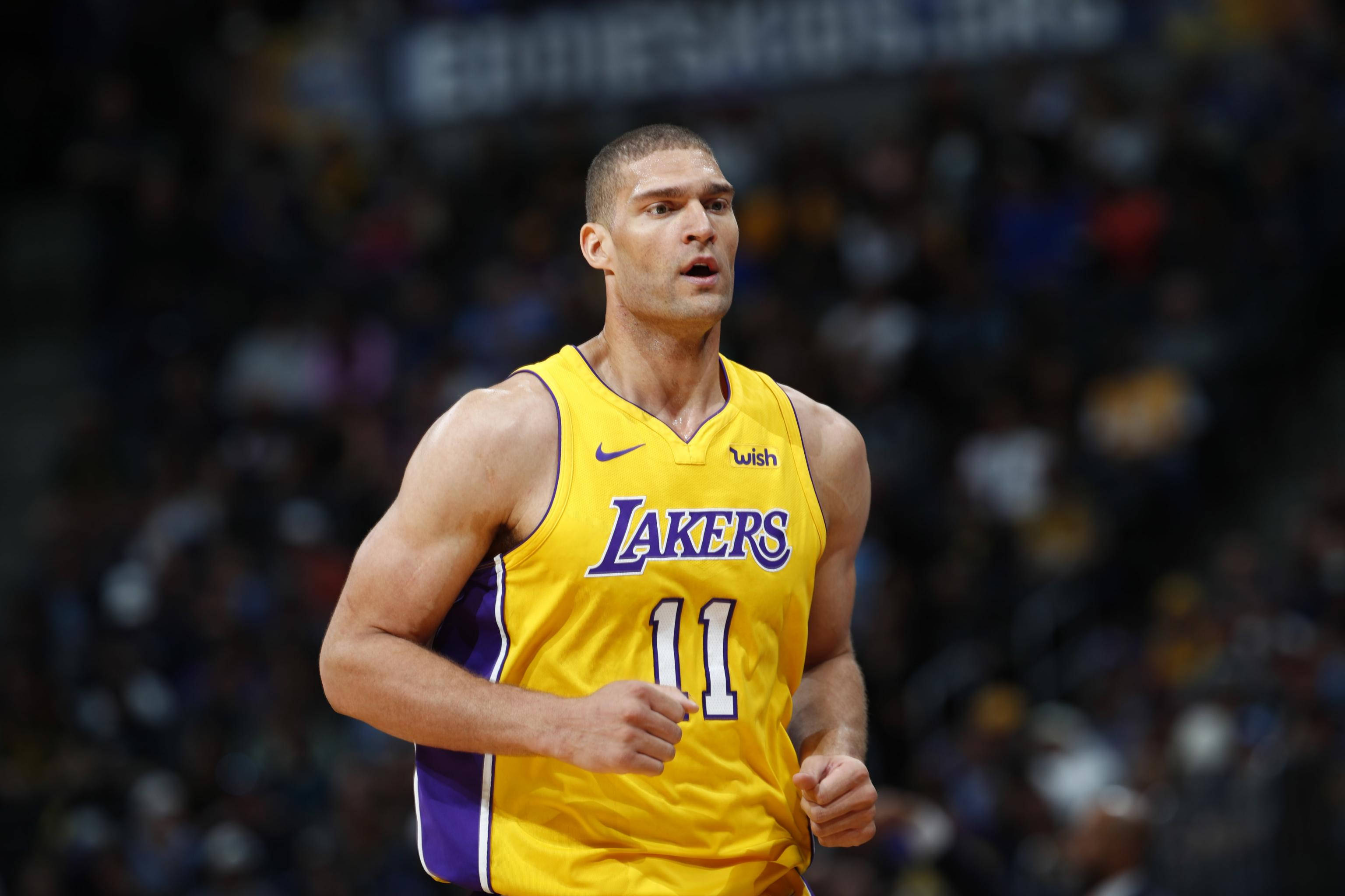 Brook 桌布 壁紙 — 一位身穿黃色湖人隊球衣、專注的籃球運動員在比賽中奔跑，身後是模糊的人群。